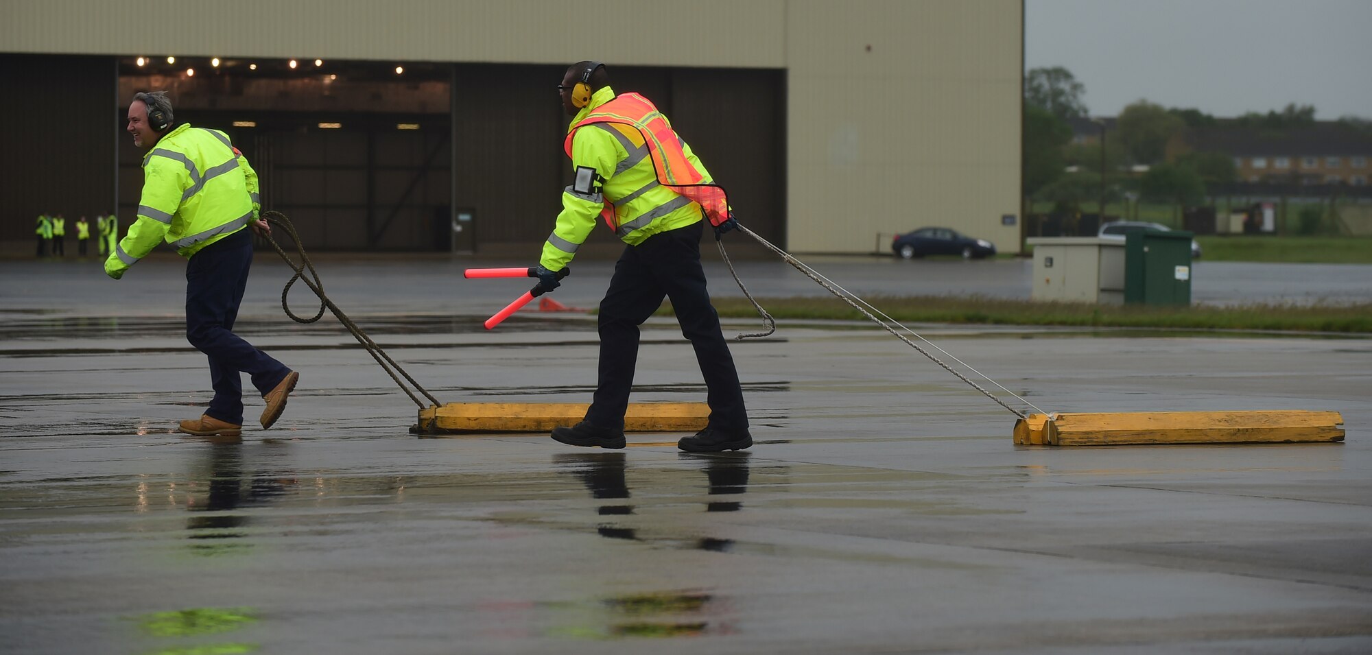 Gary Fultz, aerospace ground equipment/fuels project manager and Edmond Davis, AGE craftman, 420th Air Base Squadron, pull chalks blocks toward an aircraft to secure the wheels after landing at RAF Fairford, United Kingdom, June 2, 2015. RAF Fairford is considered a ‘warm’ base and changed to ‘hot’ status, in support of the Air Force Global Strike Command’s involvement in the BALTOPS and Saber Strike 15 exercises. (U.S. Air Force photo by Tech. Sgt. Chrissy Best)