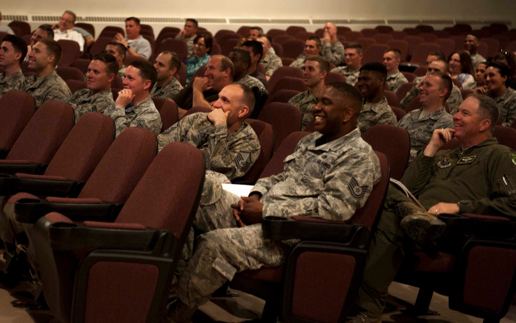 Airmen in the audience laugh during a presentation at Minot Air Force Base, N.D., June 5, 2015. Ed Hochuli, NFL referee, gave a presentation on the importance of resiliency, and how to effectively balance work and life to be successful. (U.S. Air Force photo/Airman 1st Class Sahara L. Fales)