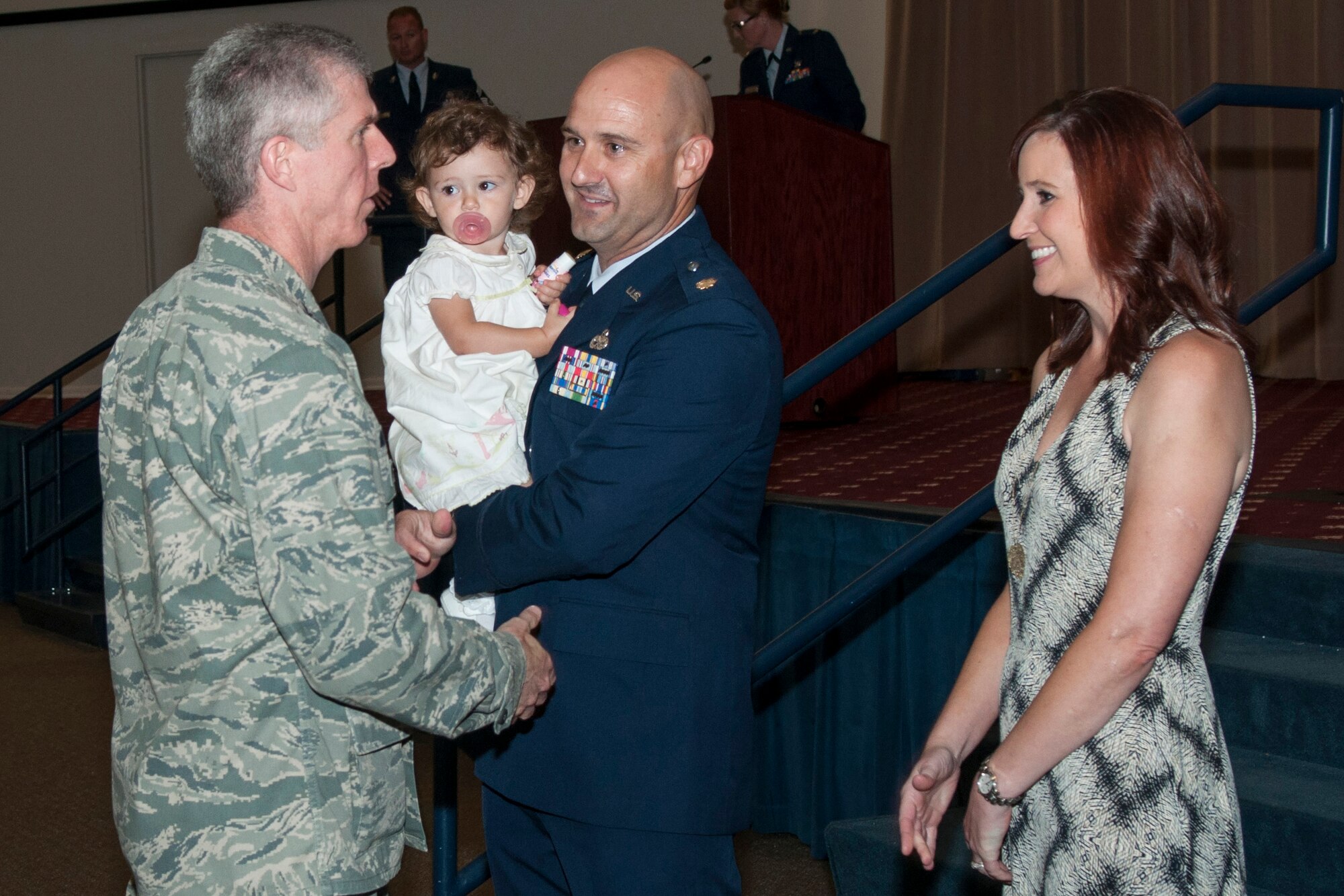 U.S. Air Force Col. Trey Morriss, the 307th Bomb Wing vice commander congratulates Maj. Brian Plauche with his family in assuming command of the 307th Aircraft Maintenance Squadron on June 6, 2015 on Barksdale Air Force Base, La. Plauche is the former Operations Officer for the 707th Maintenance Squadron. (U.S. Air Force photo by Master Sgt. Dachelle Melville/Released)