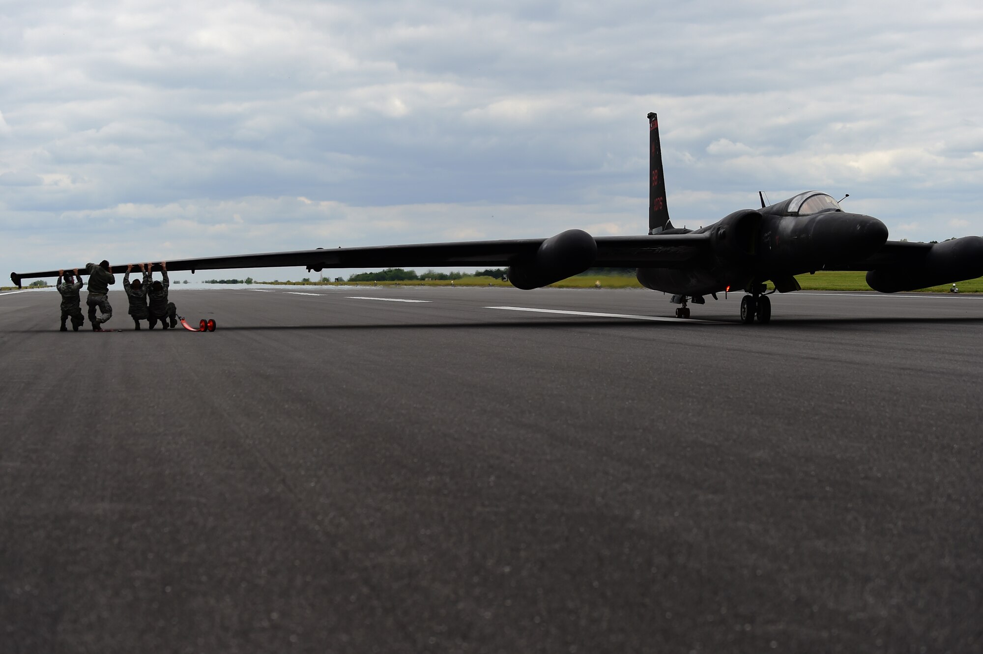 U.S. Air Force Airmen push down on the wing of a U-2 Dragon Lady after its landing at RAF Fairford, United Kingdom, June 9, 2015. Following a U-2’s landing, teams work to reattach landing gear designed to stabilize the wings. (U.S. Air Force photo by Staff Sgt. Jarad A. Denton/Released)