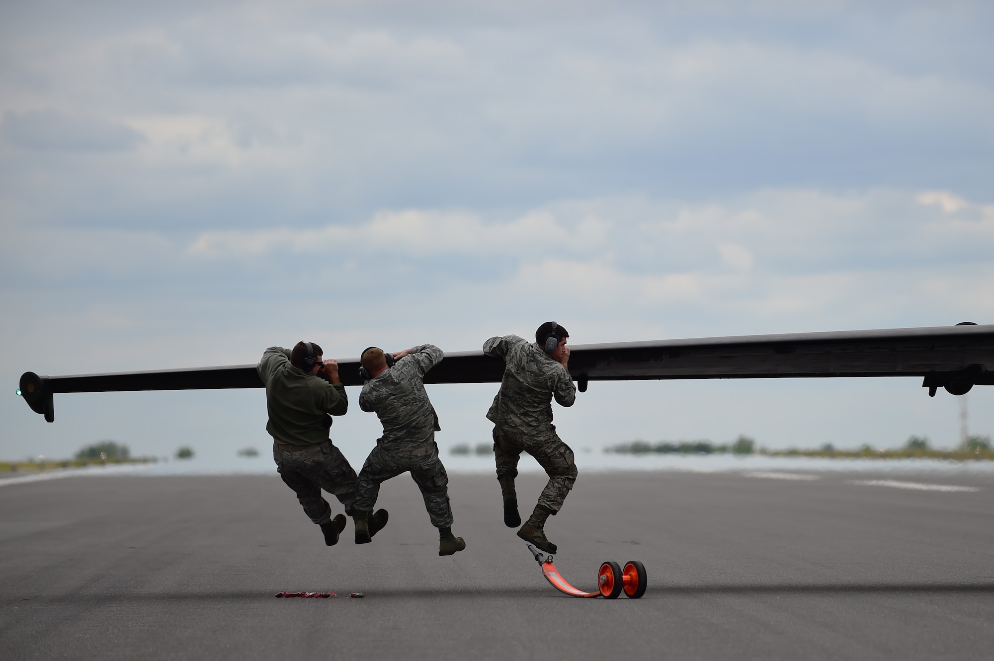 U.S. Air Force Airmen push down on the wing of a U-2 Dragon Lady after its landing at RAF Fairford, United Kingdom, June 9, 2015. If the aircraft lands slightly off balance, it has the potential to tilt to one side or another. (U.S. Air Force photo by Staff Sgt. Jarad A. Denton/Released)