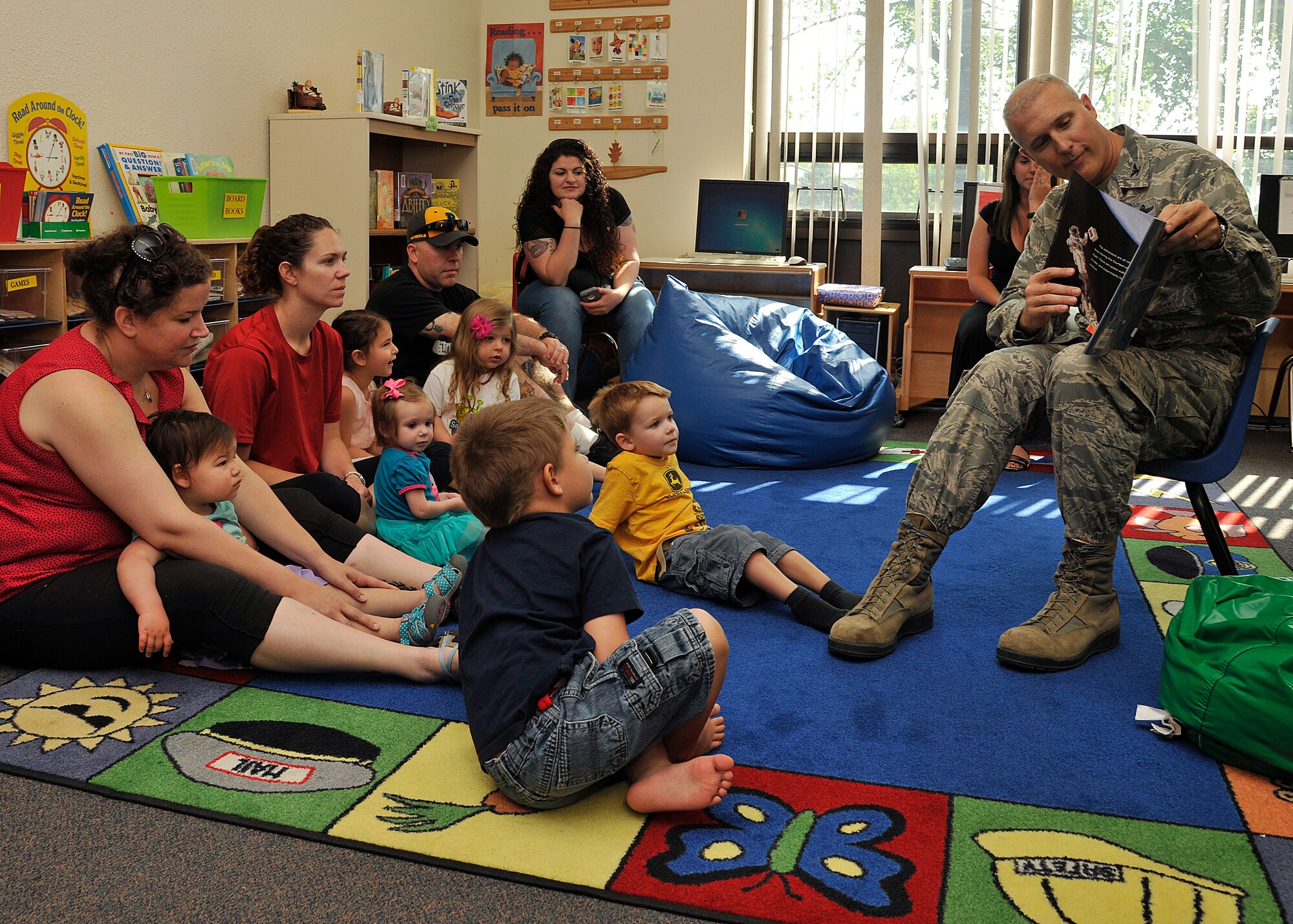 Col. Paul Bauman, 319th Air Base Wing commander, reads the book “Mousetronaut” to children at the Library on Grand Forks Air Force Base, N.D., on June 11, 2015. The library hosts weekly story time and craft sessions for young children. (U.S. Air Force photo by Senior Airman Xavier Navarro/released)