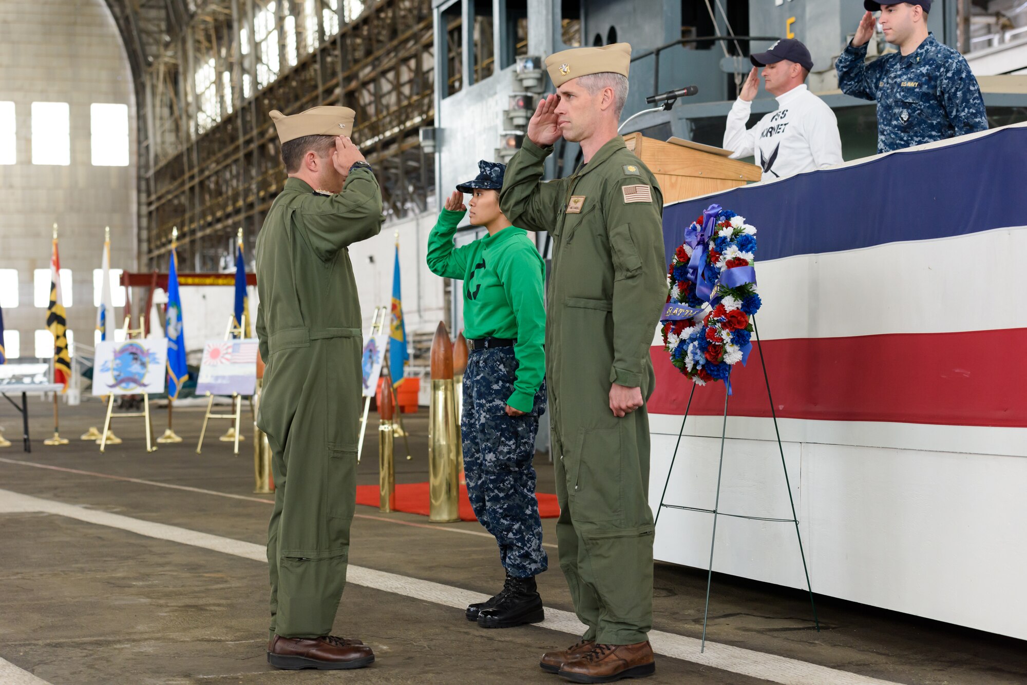 Navy Capt. Christopher Fletcher, Naval Support Activity Lakehurst commander and Joint Base McGuire-Dix-Lakehurst Deputy commander, receives salutes from Lt. Cmdr. Walt Sandell, Lakehurst air operations officer, and Aviation Boatswain’s Mate Seaman Kayla Laorosa, at the laying of the wreath ceremony commemoration of the 73rd Anniversary of the Battle of Midway, June 6, 2015. (U.S. Air Force photo by Robert Williard/Released)