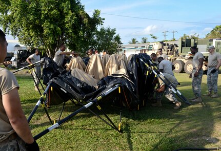Members of the Joint Task Force-Bravo Army Forces Battalion set up temporary shelters for medical readiness exercise participants June 1, 2015, at Puerto Cortes Naval Station, Honduras. The ARFOR Battalion provided temporary shelters, supplies, communication support and many other amenities to the MEDRETE, supporting more than 100 participants. (U.S. Air Force photo by Staff Sgt. Jessica Condit)
