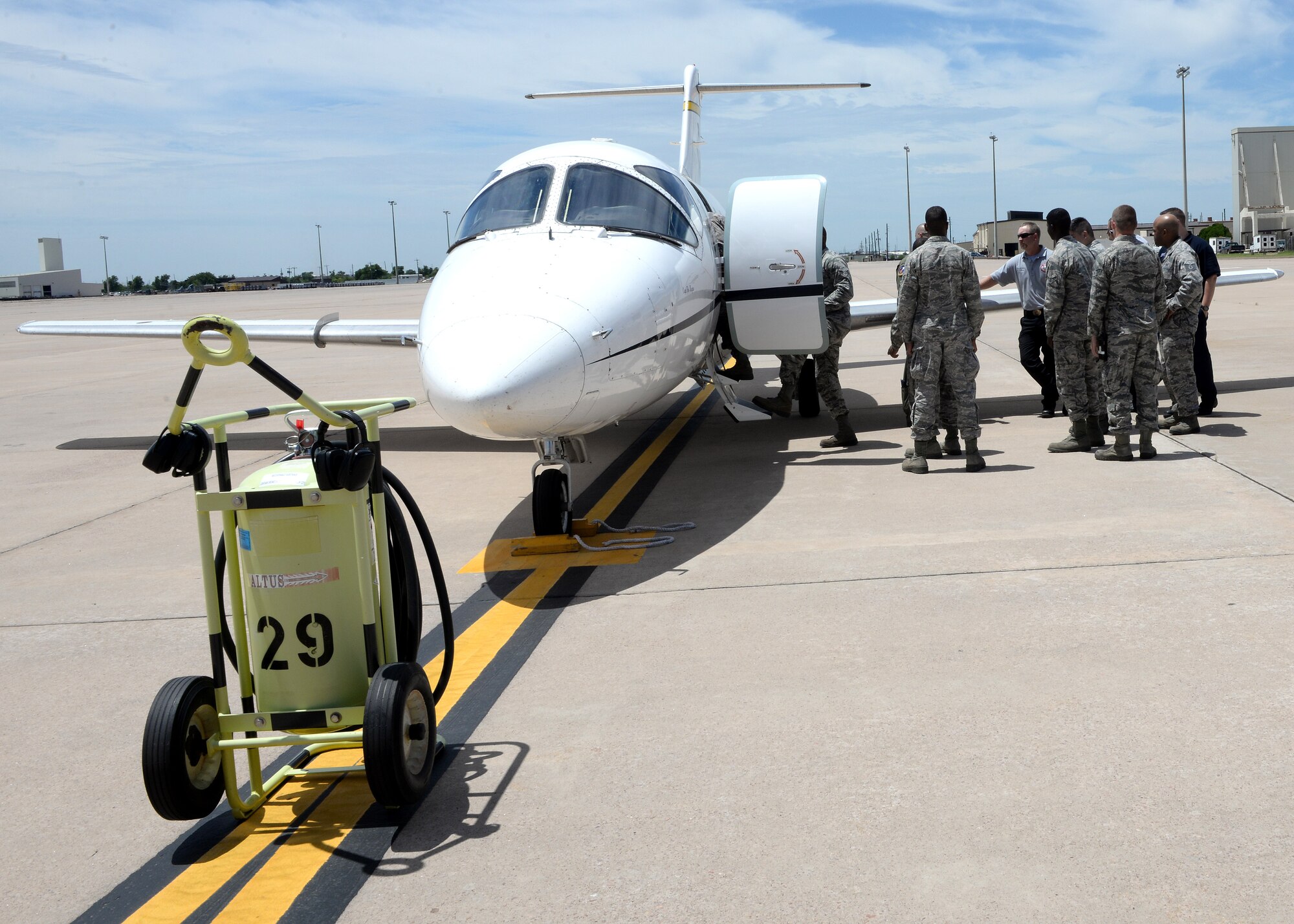 ALTUS AIR FORCE BASE, Okla. – Firefighters with the 97th Civil Engineer Squadron gather beside a T-1 Jayhawk aircraft on the flight line for egress training, June 8, 2015. Egress training involves learning how to enter an aircraft to rescue any personnel on board should they become incapacitated during an emergency situation, as well as learning how to shut off the aircraft. (U.S. Air Force photo by Airman 1st Class Megan E. Acs/Released) 