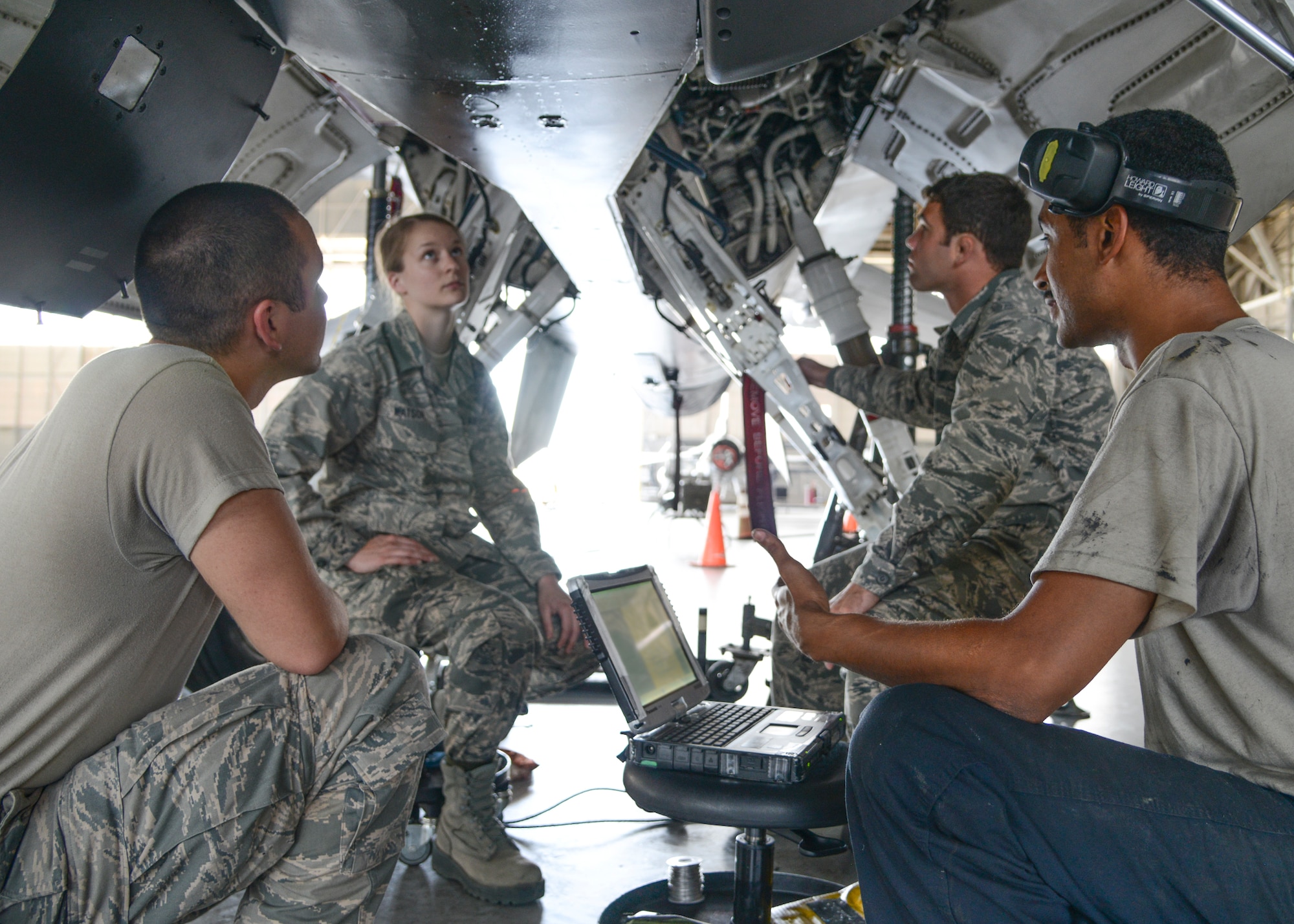 Staff Sgt. Kelvin Mills (right), 412th Aircraft Maintenace Squadron, teaches (left to right) Cadets Casen Askew, Andrea Watson and David Walker how to perform operational checks for a landing gear installation on an F-16. (U.S. Air Force photo by Rebecca Amber)
