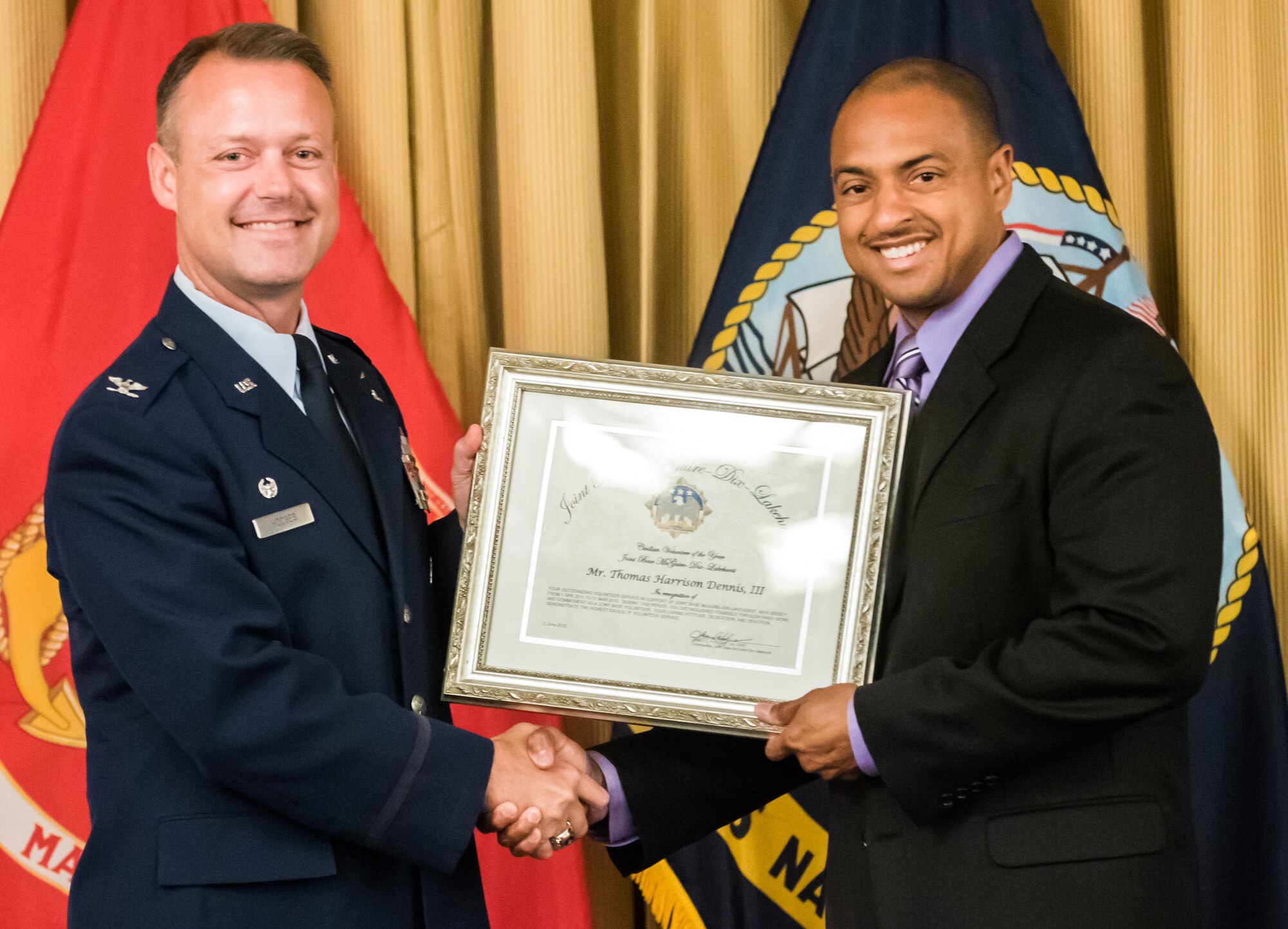 Col. James Hodges, Joint Base McGuire-Dix-Lakehurst commander, presents Thomas Harrison Dennis with the 2015 JB MDL Civilian Volunteer Award during the Volunteer Appreciation Day luncheon June 2, 2015 at Tommy B's Community Activities Center here. The ceremony honored the hard work and dedication of those who sacrificed their time throughout the year to support the joint base. (U.S. Air Force photo by Russell Meseroll/Released)