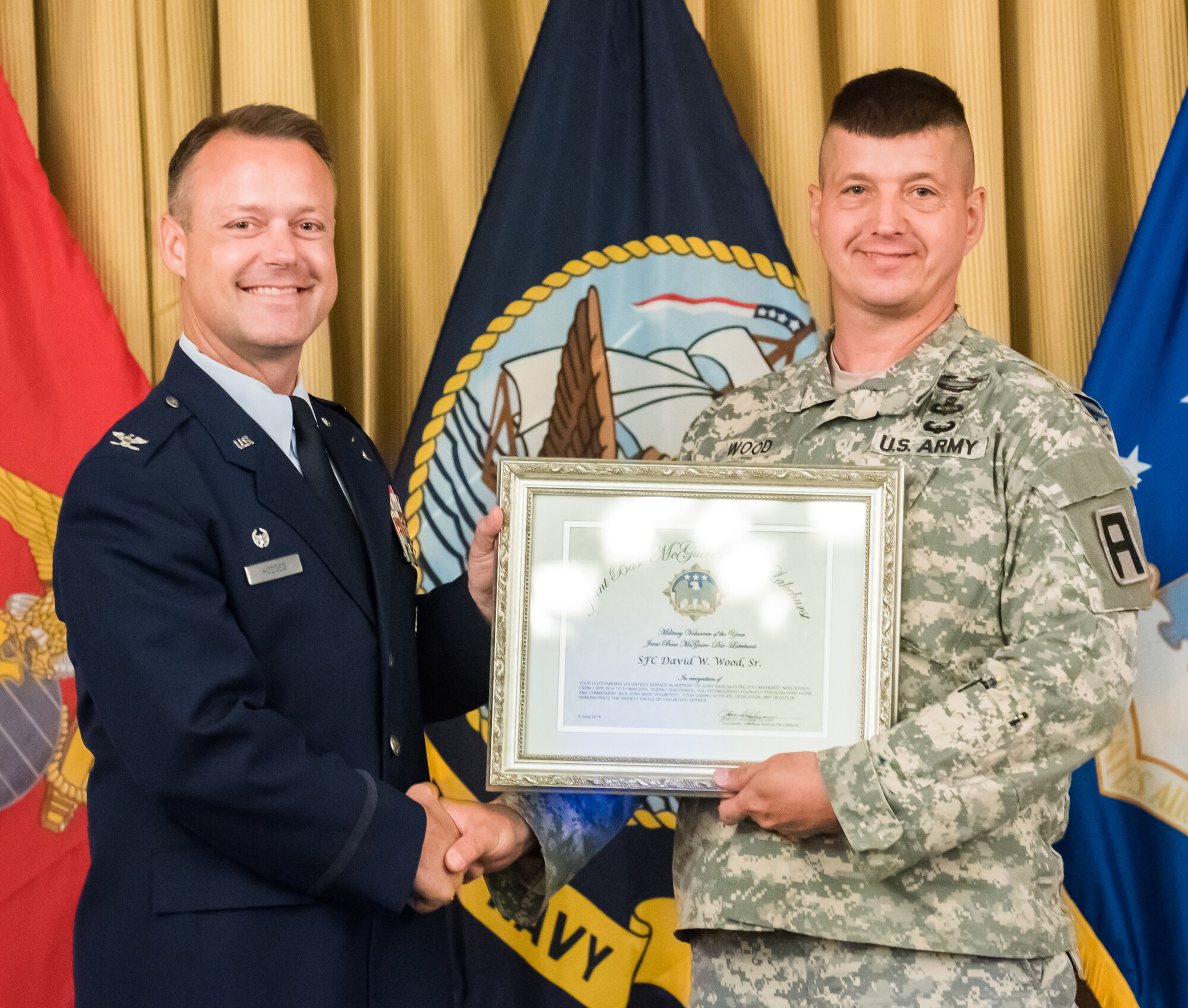 Col. James Hodges, Joint Base McGuire-Dix-Lakehurst commander, presents Sgt. 1st Class David Wood, 174th Infantry Brigade, with the 2015 JB MDL Military Volunteer Award during the Volunteer Appreciation Day luncheon June 2, 2015 at Tommy B's Community Activities Center here. In the past year, 900 registered volunteers have provided more than 76,000 hours of service to the joint base. (U.S. Air Force photo by Russell Meseroll/Released)