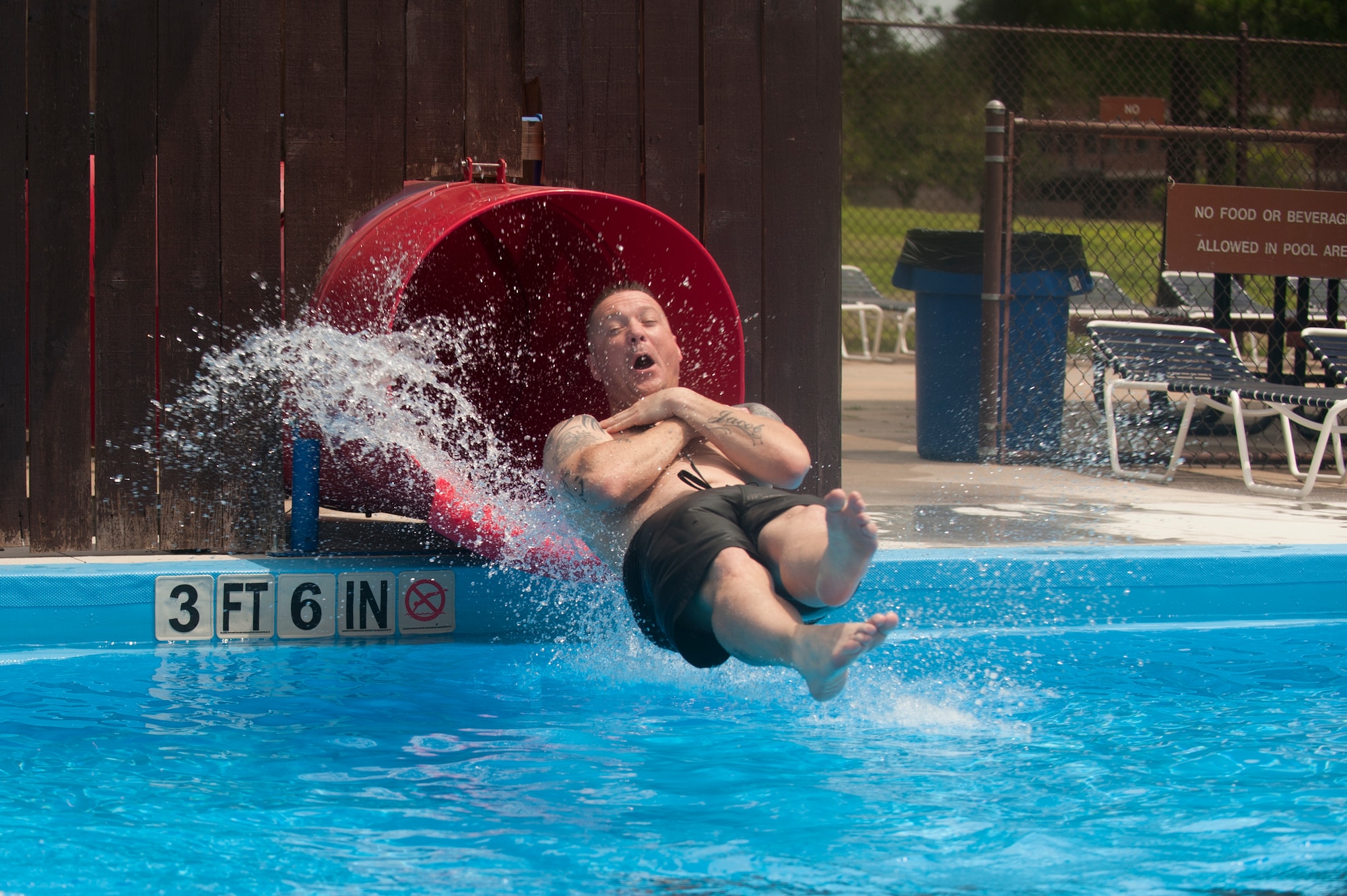 Chief Master Sgt. Donnie Bolton, 19th Security Forces Squadron manager, slides down the water slide at the base pool June 6, 2015, at Little Rock Air Force Base, Ark. The base pool is open Tuesday through Sunday from noon – 7 p.m. (U.S. Air Force photo by Senior Airman Scott Poe) 