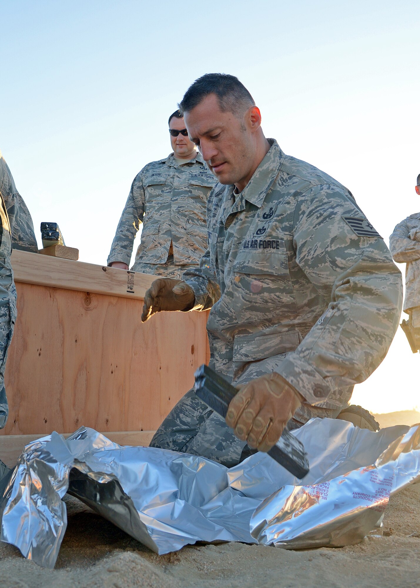 Tech. Sgt. James Bennett, 412th Civil Engineer Group Explosive Ordnance Disposal technician and NCOIC of Administration and Technical Orders, unpacks C-4 explosives during a detonation and disposal event June 8 at the Open Burn/Open Detonation range. The EOD team used approximately 412 pounds of C-4 explosive to dispose of approximately 500 pounds of NASA ordnance that had been stockpiled for 30 to 50 years. (U.S. Air Force photo by Jet Fabara)