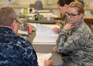 U.S. Air Force Capt. Lucy Knippenburg, Langley dental resident, listens to U.S. Navy Lt. Cmdr. Robert Ruehrwein, Little Creek Boone Clinic dental officer, explain her assignment during a dental forensics training course at Langley Air Force Base, Va., June 5, 2015. Three U.S. Navy dental officers and U.S. Navy Capt. Kevin Torske, Naval Medical Center Portsmouth staff pathologist, trained U.S. Air Force and Navy dental residents on the principles of forensic dentistry. (U.S. Air Force photo by Airman 1st Class Devin S. Michaels/Released)