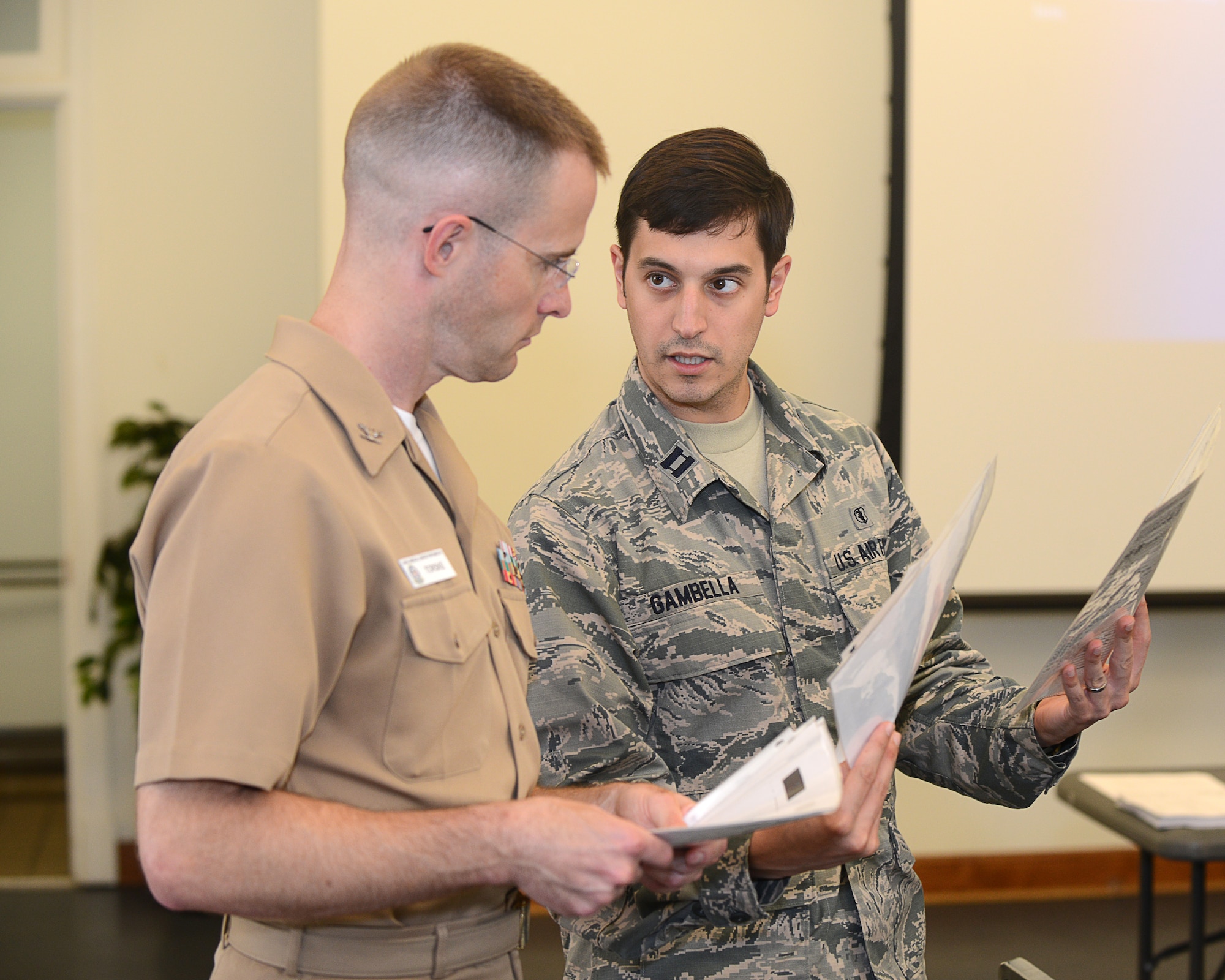 U.S. Air Force Capt. Americo Gambella, Langley dental resident, asks U.S. Navy Capt. Kevin Torske, Naval Medical Center Portsmouth staff pathologist, a question about his group assignment during a dental forensics training course at Langley Air Force Base, Va., June 5, 2015. After medical school and Air Force Officer Training School, these dentists become a resident at one of 10 possible assignments and participate in the Advanced Educational General Dentistry program. (U.S. Air Force photo by Airman 1st Class Devin S. Michaels/Released)