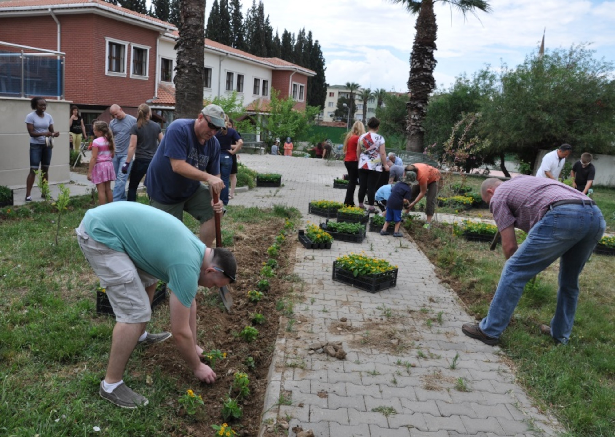NATO and 425th Air Base Squadron members plant flowers at a local girls’ care and rehabilitation center garden as part of a landscaping project June 6, 2015. (U.S. Air Force photo by Tanju Varlikli/released)
