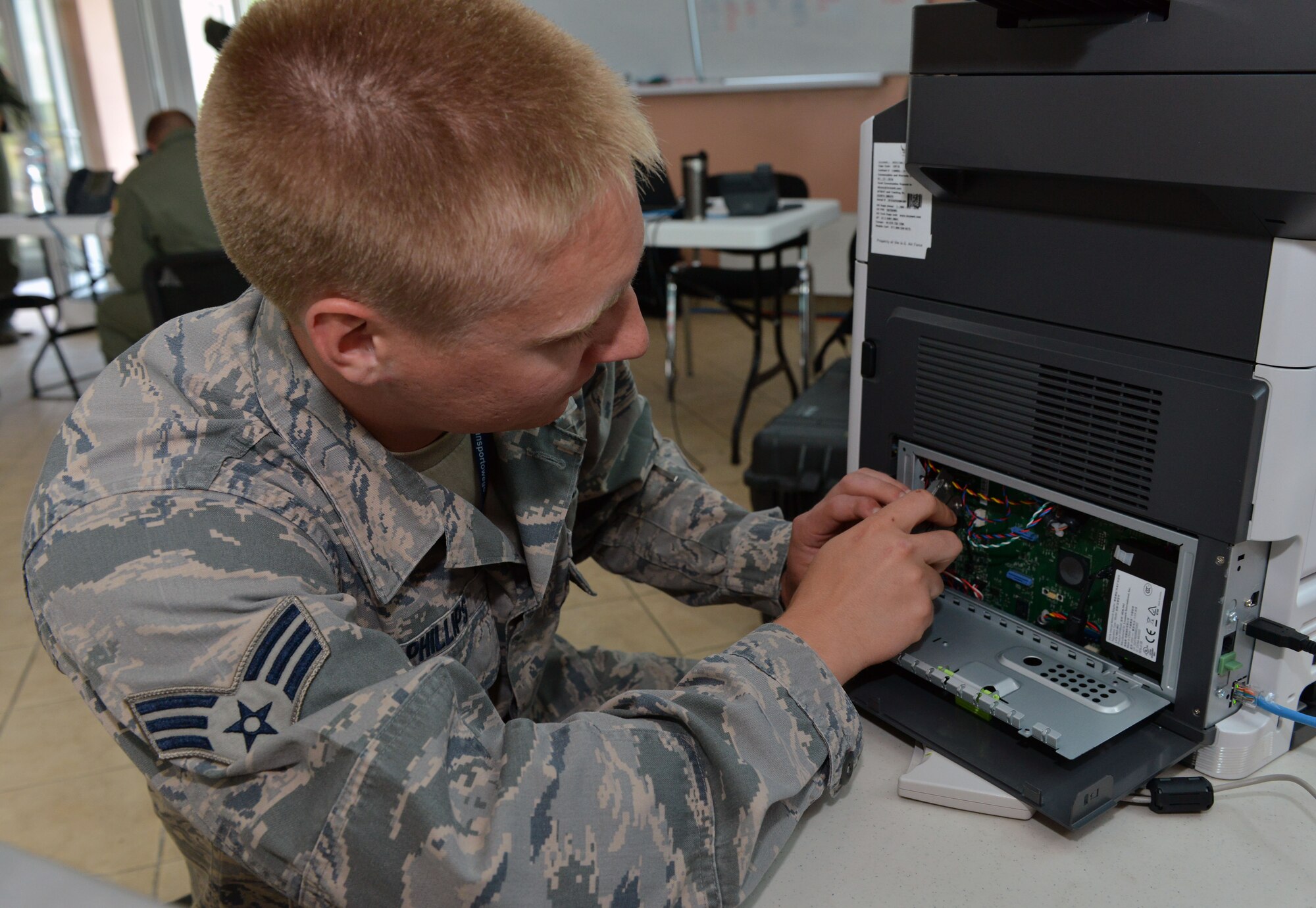 Senior Airman Ian Philips, 1st Combat Communications Squadron tactical network operations technician, replaces a printer motherboard during Baltic Operations 2015, June 10, 2015, at Powidz Air Base, Poland. The U.S., NATO and partner nations sent 49 ships, 61 aircraft, one submarine, and approximately 5,600 Sailors, Marines, airmen, and soldiers to employ land, air, sea and undersea capabilities. (U.S. Air Force photo by Senior Airman Michael Battles)