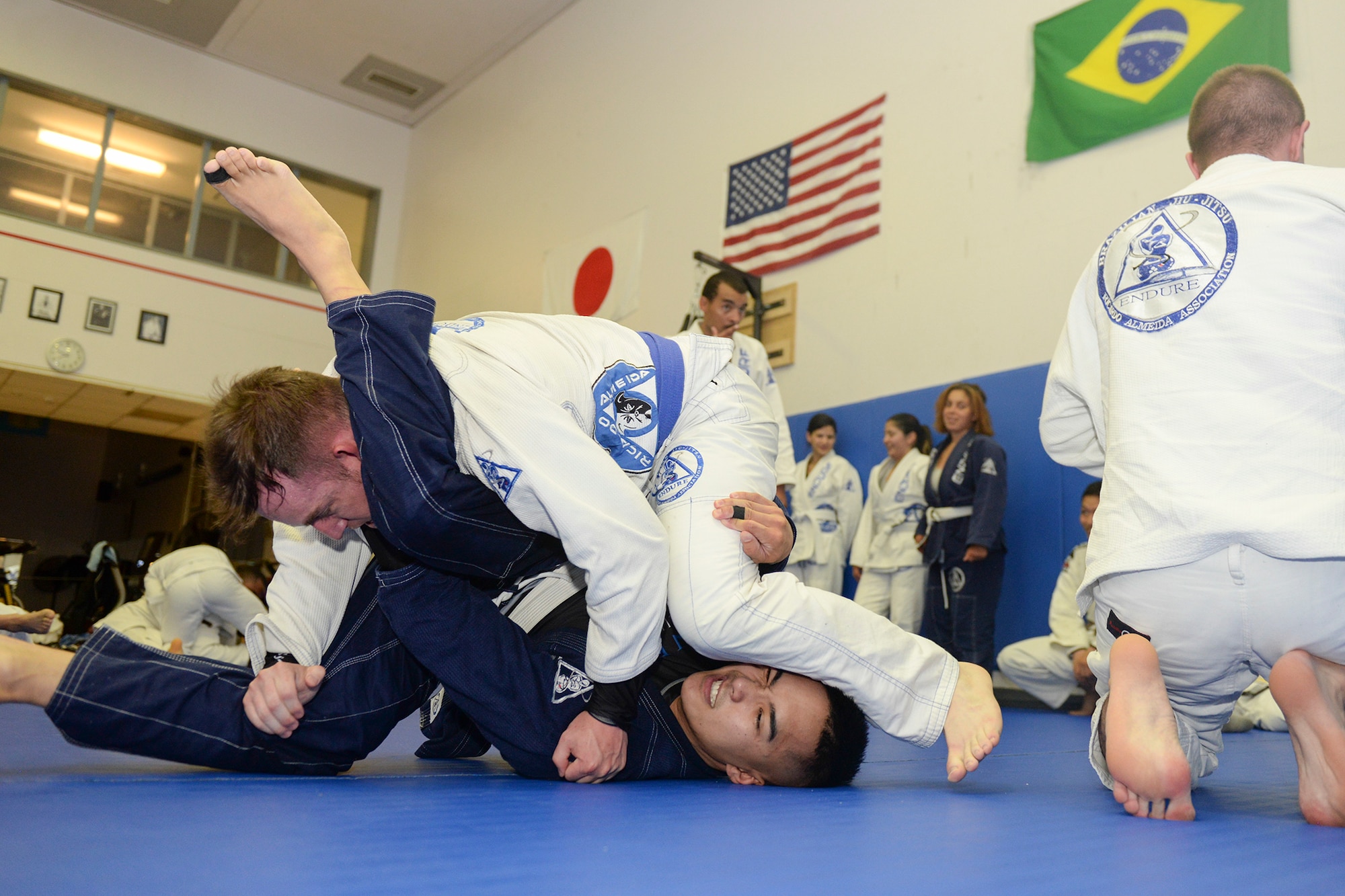 Staff Sgt. Ryan Underwood, 374th Communications Squadro, tries to pass the guard of his opponent, Senior Airman Vonfernan Carios, 374th Aerospace Medicine Squadron, during an jiu-jitsu class sparing session at Yokota Air Base, Japan, June 10, 2015. Sparing helps students improve muscle-memory and build fighting endurance. (U.S. Air Force photos by Airman 1st Class Elizabeth Baker/Released)
