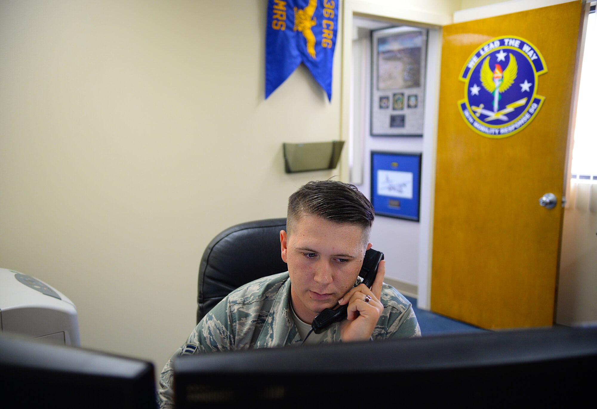 Senior Airman Presley Griffith, a command support staff executive assistant, works at his office in the 36th Mobility Response Squadron June 6, 2015, Andersen Air Force Base, Guam. Griffith created a free spring practice camp to offer local high school athletes an additional mentoring and practice opportunity before football season begins. (U.S. Air Force photo by Senior Airman Alexander W. Riedel/Released)