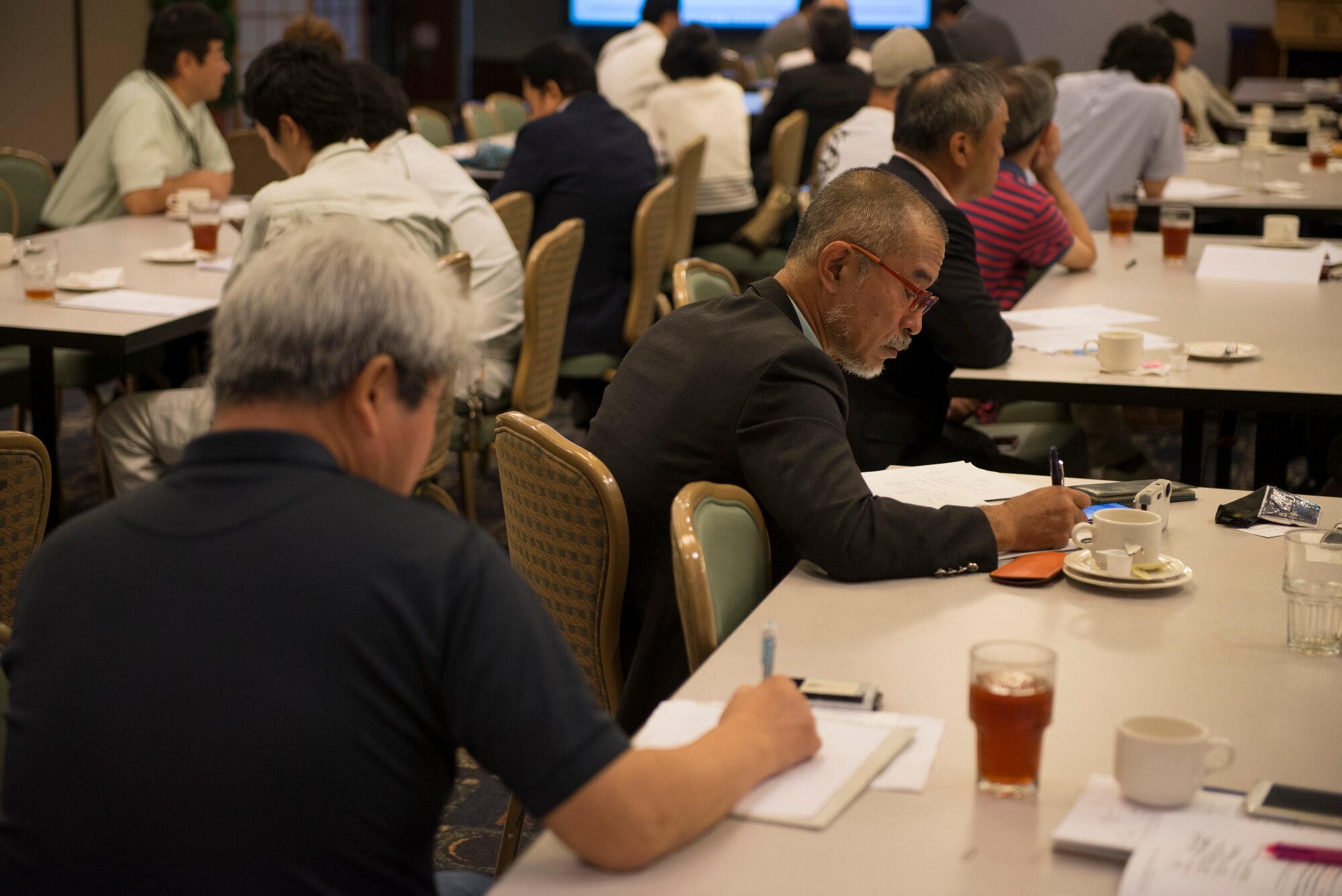 Representatives from local businesses take notes during a Vendor Fair at Yokota Air Base, Japan, June 10, 2015.  More than 90 participants from 70 businesses came to the event to learn more about working with the U.S. government. (U.S. Air Force photo by Staff Sgt. Cody H. Ramirez/Released)