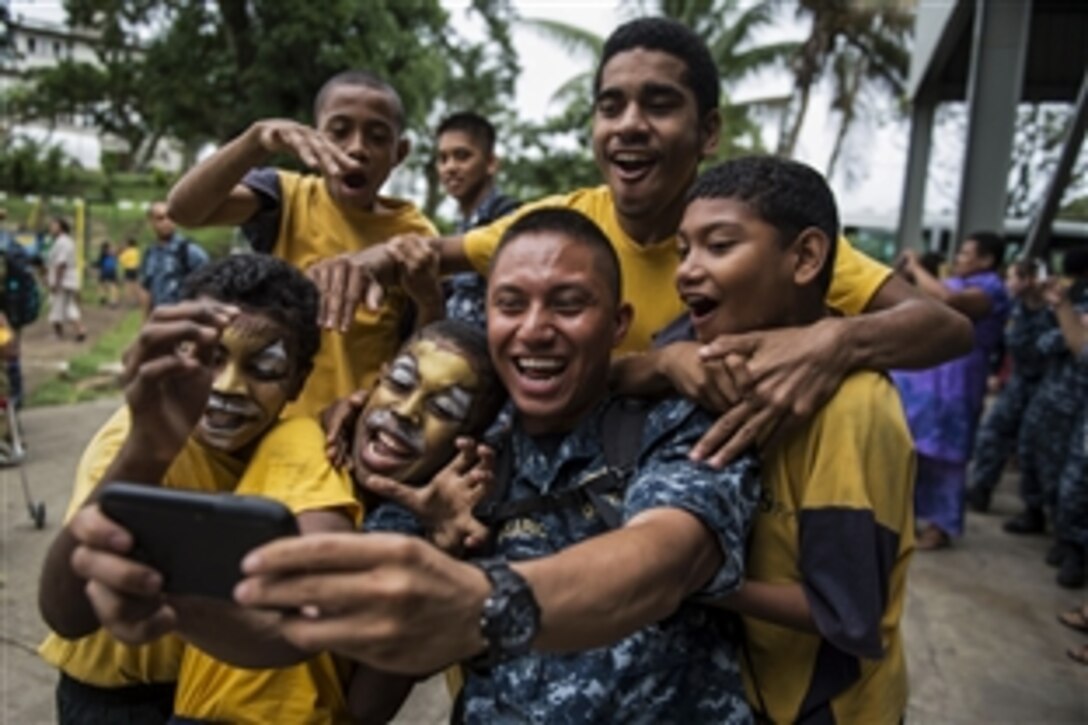 U.S. Navy Lt. j.g. Jomer Belisario takes a selfie with Fijian students at Hilton Special School during Pacific Partnership 2015 in Suva, Fiji, June 10, 2015. Fiji is Mercy’s first mission port during the exercise.
