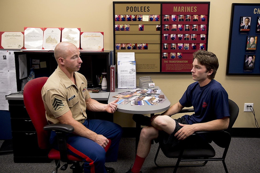 Sgt. Cody Leifheit, a Marine recruiter in Lewiston, Idaho, answers enlistee Brandon Roberts’ questions about the Marine Corps at his recruiting office June 10, 2015. Leifheit, a 28-year-old infantry Marine from Ferndale, Washington, responded to a 19-year-old man hanging himself from a tree outside his house June 7. Without hesitation, Leifheit climbed up the tree 25 feet and took hold of the man, who wasn’t breathing and lacked a pulse. Leifheit worked to keep him alive until first responders arrived, continuously performing chest compressions as the man faded in and out. Despite spending 48 hours in a coma, the man survived. (U.S. Marine Corps photo by Sgt. Reece Lodder)