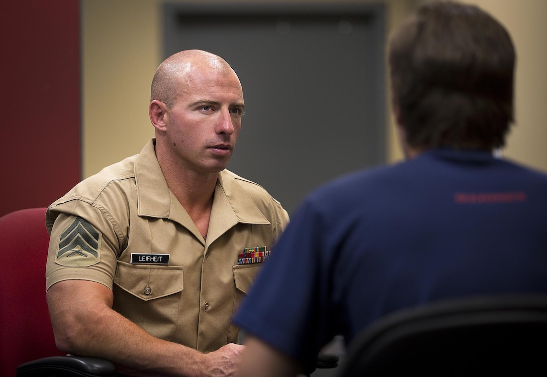 Sgt. Cody Leifheit, a Marine recruiter in Lewiston, Idaho, answers questions about the Marine Corps from enlistee Brandon Roberts at his recruiting office June 10, 2015. Leifheit, a 28-year-old infantry Marine from Ferndale, Washington, responded to a 19-year-old man hanging himself from a tree outside his house June 7. Without hesitation, Leifheit climbed up the tree 25 feet and took hold of the man, who wasn’t breathing and lacked a pulse. Leifheit worked to keep him alive until first responders arrived, continuously performing chest compressions as the man faded in and out. Despite spending 48 hours in a coma, the man survived. (U.S. Marine Corps photo by Sgt. Reece Lodder)