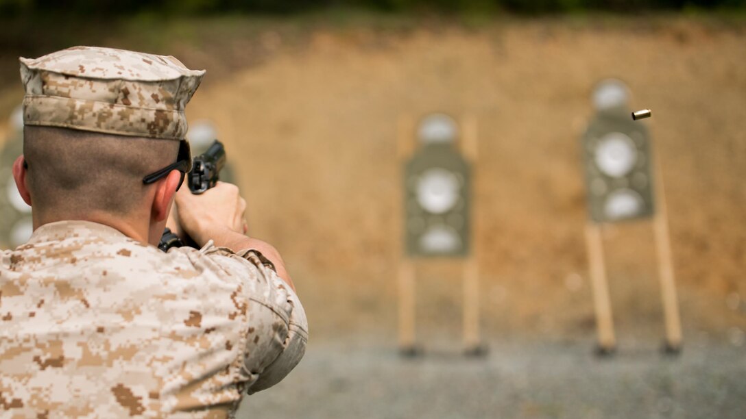 A Guard Marine with Marine Barracks Washington, shoots an M9 service pistol during a training exercise at Range 5, Marine Corps Base Quantico, Virginia, June 10, 2015. 1st platoon, Guard Company, traveled there to increase overall marksmanship with the M9 service pistol, the M4 service rifle and M1014 shotgun.
