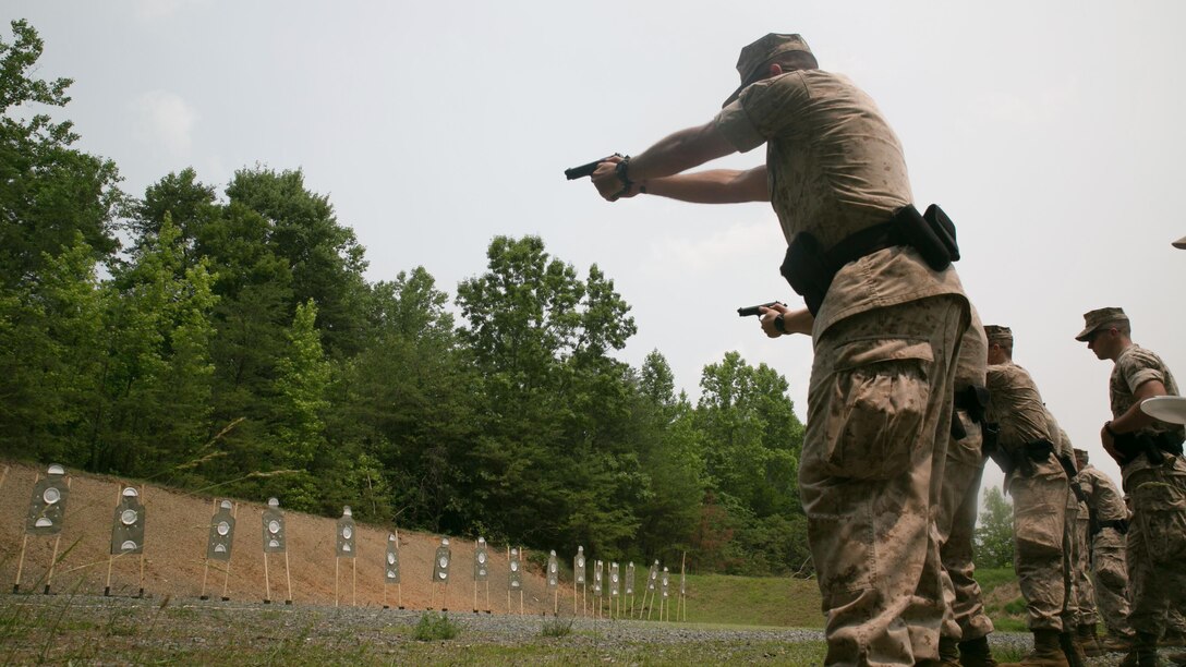 A Guard Marine from Marine Barracks Washington, shoots an M9 service pistol during a training exercise at Range 5, Marine Corps Base Quantico, Virginia, June 10, 2015. 1st platoon, Guard Company, traveled there to increase overall marksmanship with the M9 service pistol, the M4 service rifle and M1014 shotgun. “By the time these Marines leave Guard Company we are hoping that they have mastered the fundamentals of marksmanship,” said Capt. Greg Jurschak, 1st platoon commander, Guard Co. “We also want to hone their decision making and judgment skills. It’s not only having good fundamentals it is knowing the right place, the right time and the right reason to actually employ their weapons.”
