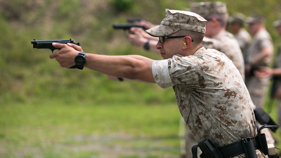 A Guard Marine with Marine Barracks Washington, shoots an M9 service pistol during a training exercise at Range 5, Marine Corps Base Quantico, Virginia, June 10, 2015. 1st platoon, Guard Company, traveled there to increase overall marksmanship with the M9 service pistol, the M4 service rifle and M1014 shotgun. 