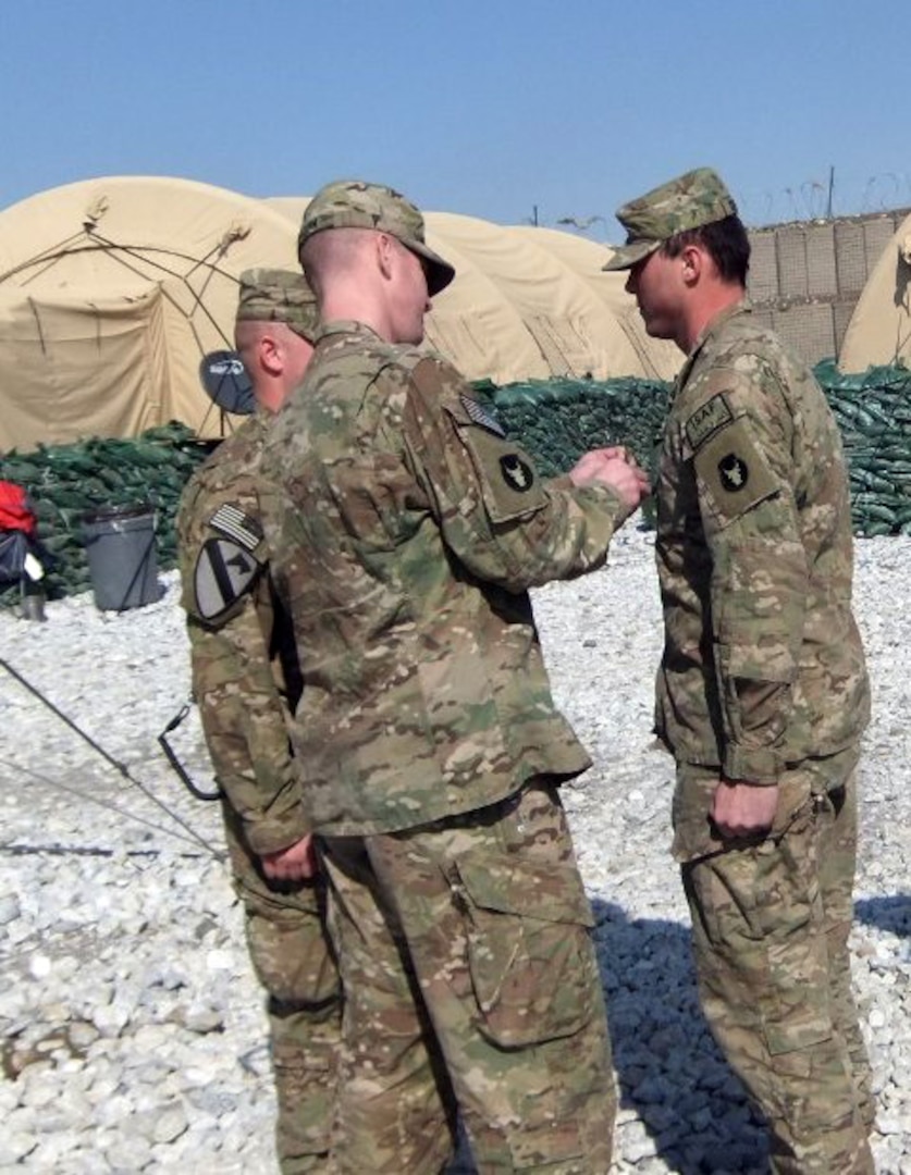 Army Sgt. 1st Class Garry Waldon Jr., acting  first sergeant for Headquarters and Headquarters Company, 334th Brigade Support  Battlaion, Task Force Archer, helps promote his brother, Army Sgt. Brandon  Corbett, a truck commander with Troop A, 1st Squadron, 113th Calvary Regiment,  Task Force Redhorse, at Combat Outpost Pul-E-Sayad, Panjshir Province,  Afghanistan, Feb. 7, 2011. Waldon and Corbett followed in their father's  footsteps -- retired Army Staff Sgt. Garry Waldon Sr. -- by serving in the Iowa  Army National Guard. TF Archer and TF Redhorse belong to the 34th Infantry  Division’s 2nd Brigade Combat Team.