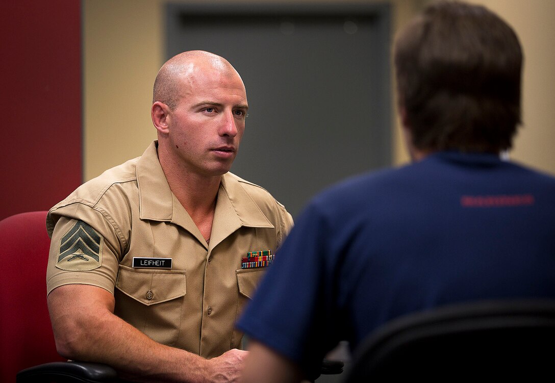 Sgt. Cody Leifheit, a Marine recruiter in Lewiston, Idaho, answers questions about the Marine Corps from enlistee Brandon Roberts at his recruiting office June 10, 2015. Leifheit, a 28-year-old infantry Marine from Ferndale, Washington, responded to a 19-year-old man hanging himself from a tree outside his house June 7. Without hesitation, Leifheit climbed up the tree 25 feet and took hold of the man, who wasn’t breathing and lacked a pulse. Leifheit worked to keep him alive until first responders arrived, continuously performing chest compressions as the man faded in and out. Despite spending 48 hours in a coma, the man survived. (U.S. Marine Corps photo by Sgt. Reece Lodder)