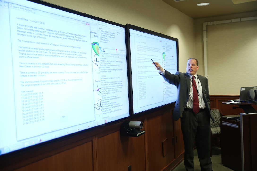 NEW ORLEANS- Dr. Cameron MacKenzie, an assistant professor at the Naval Postgraduate School, presents the Matlab Hurricane Decision Simulator to the commander of Marine Forces Reserve and Marine Forces North, June 11, 2015, at Marine Corps Support Facility New Orleans.  The hurricane decision simulator depicts tropical cyclones that threaten to strike New Orleans. A forecast includes the chances the storm will strike New Orleans, the expected time until landfall, and information about the wind speed. Based on the forecast, the user must make decisions in the simulation about steps to prepare MARFORRES for the oncoming cyclone, such as whether or not to evacuate. (U.S. Marine Corps Photo by Cpl. J. Gage Karwick/Released)  
