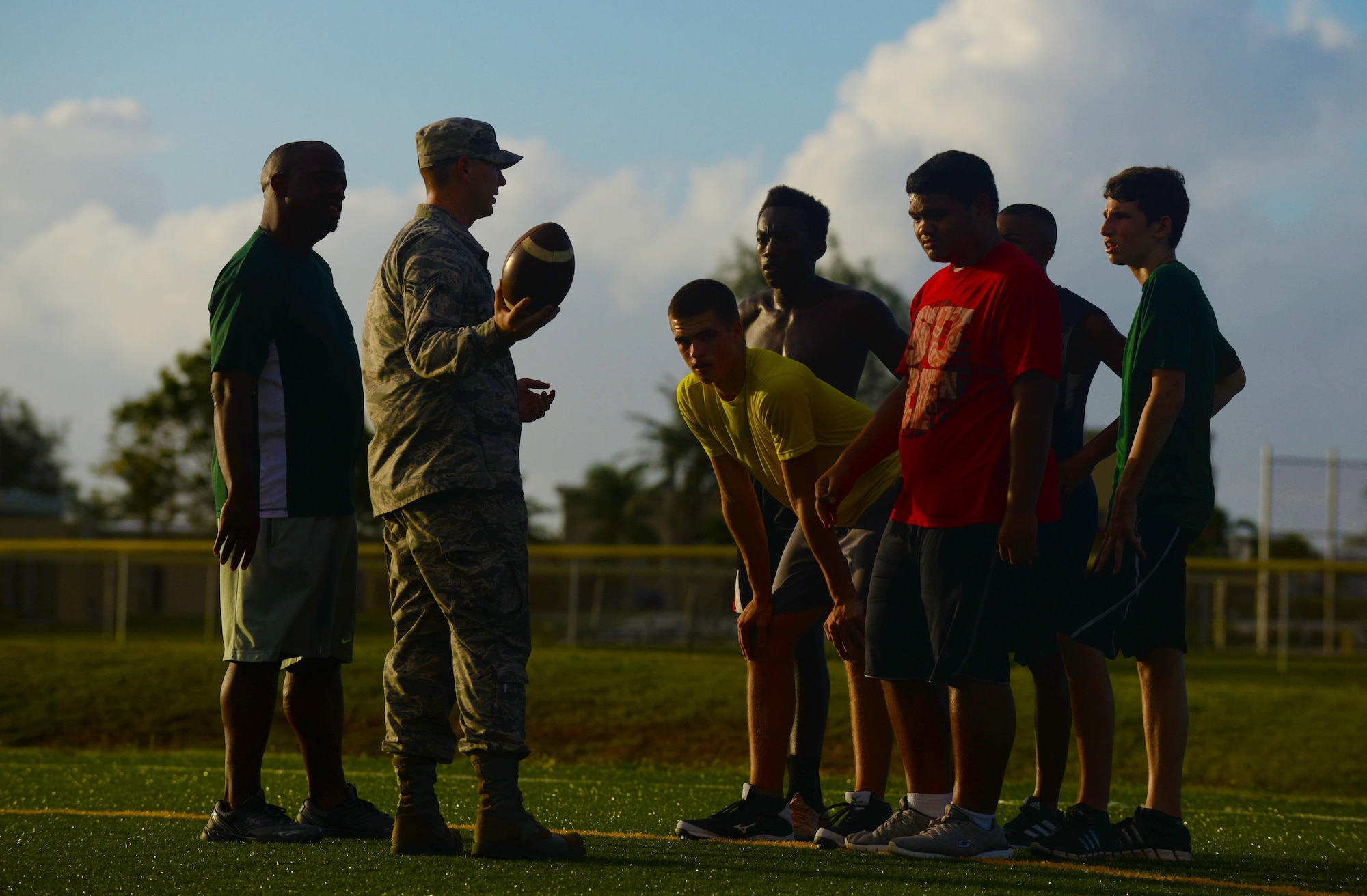 Jacob Dowdell, the Guam High School head coach, left, supervises Senior Airman Presley Griffith, a 36th Mobility Response Squadron executive assistant, second from left, as he teaches a free football spring practice camp June 8, 2015, at Andersen Air Force Base, Guam. Griffith hopes to someday become a high school football coach and volunteers his time to offer an additional preseason training opportunity to local high school athletes. (U.S. Air Force photo/Senior Airman Alexander W. Riedel)