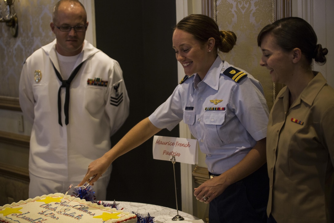 Lt. Tessa Clayton (center), a helicopter pilot at Coast Guard Air Station New Orleans, cuts the cake at the New Orleans Chef’s Salute to Our Armed Forces hosted by the Navy League at the Bourbon Orleans Hotel, June 11, 2015. For five years, chefs around New Orleans have shown support for America’s military by serving their specialty entrees to veterans free of charge, and by recognizing the enlisted service members of the year for each respective branch of the U.S. armed forces. 
