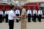 YOKOSUKA, Japan (June 11, 2015) Vice Adm. Dixon Smith, right, commander of Navy Installations Command, congratulates Yuuhei Hino, of the Commander, Navy Region Japan Fire Department, during an awards presentation at Commander Fleet Activities Yokosuka (CFAY).  CFAY provides support for ships and tenant commands in the U.S. 7th Fleet area of operations. 