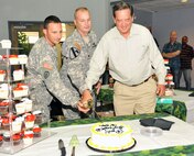 Celebrating the Army and the Corps of Engineers birthday, Lt. Col. Kendall Bergmann, Huntsville Center deputy commander, is flanked by Staff Sgt. Patrick Henry and Robert Belew to cut the birthday cake with a ceremonial sword in the Center lobby June 12. Henry, the Center’s most recent employee, processed into the Center June 10. Belew, the Center employee with the longest tenure, began his Corps career in 1984.