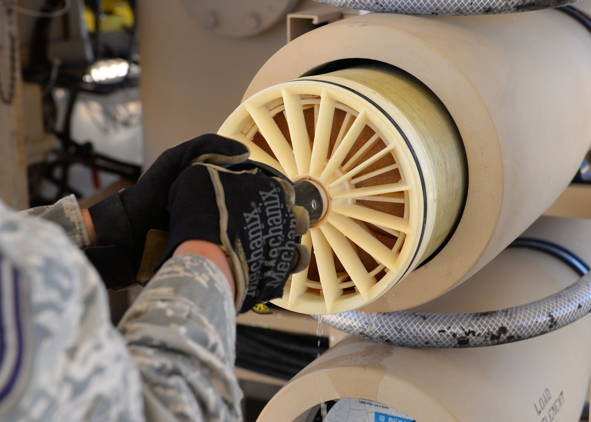 Tech. Sgt. Roshia Johari, the 554th RED HORSE NCO in charge of water fuels systems maintenance contingency training, uses an extraction tool to pull elements from their vessels on a Reverse Osmosis Water Purification Unit June 9, 2015, at Andersen Air Force Base, Guam. Pacific Air Forces Command Silver Flag instructors from the 554th RED HORSE Squadron train service members from Air Force bases, other military branches and different nations once a month on how to properly use the unit. (U.S. Air Force photo/Airman 1st Class Joshua Smoot)