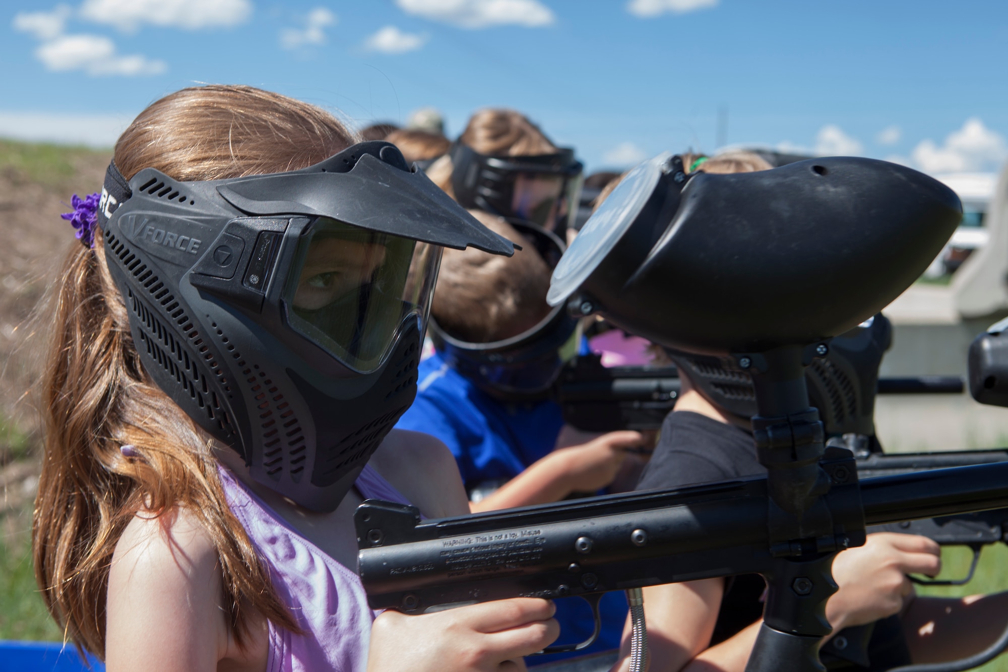 Samara Wright, 8, daughter of Master Sgt. Steven Wright, 20th Air Force enlisted aide, shoots paintballs at the paintball field obstacle course on F.E. Warren Air Force Base, Wyo., June 9, 2015. Shooting the paintballs was one of the activities Outdoor Recreation hosted as part of Basic Recreation Adventure Training Camp for children aged 7-10. (U.S. Air Force photo by Lan Kim)