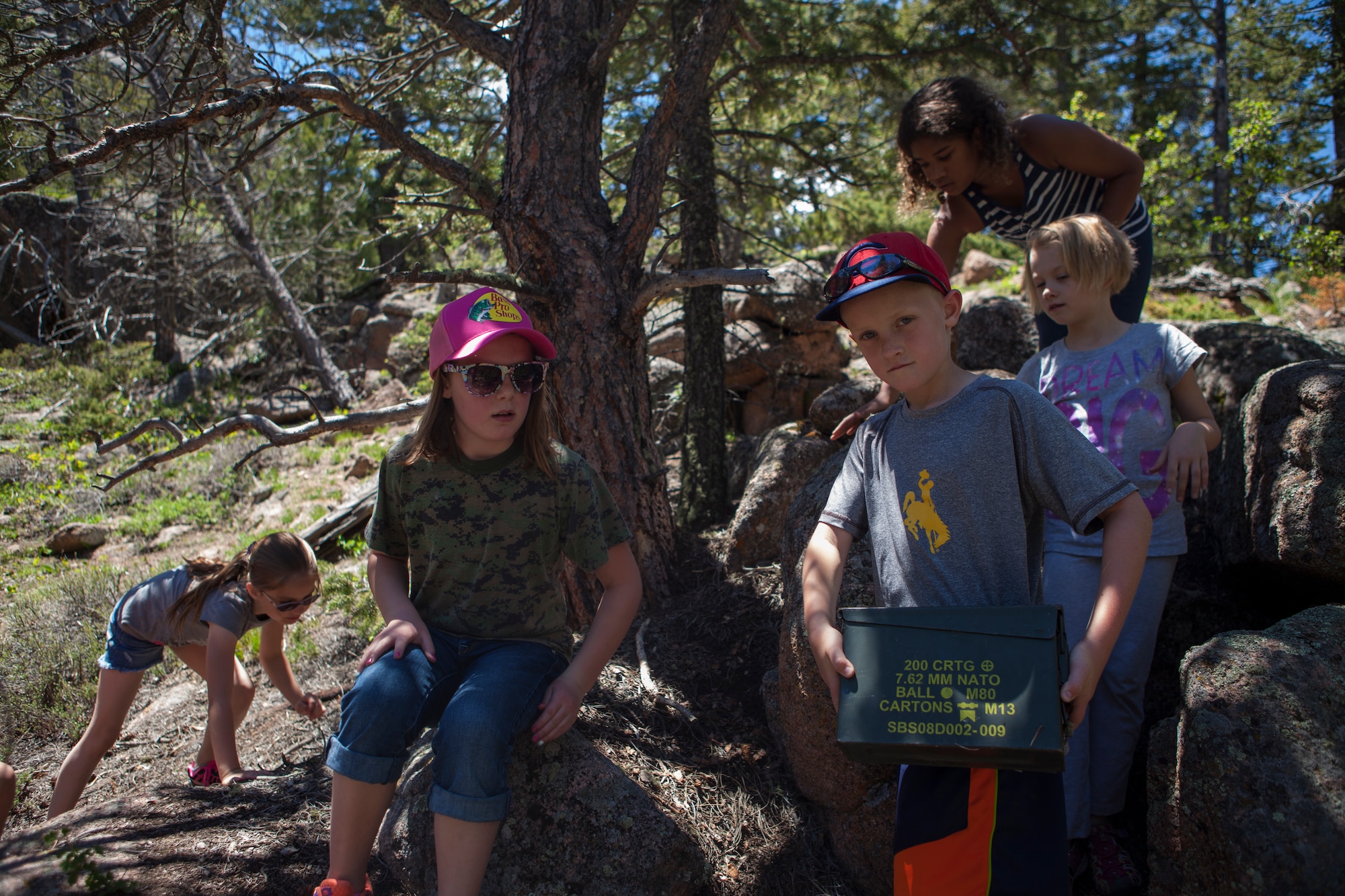 Race Morrell, 7, son of Allison Morrell, 90th Medical Operations Squadron, holds a Geocache container found in the Vedauwoo Recreation Area of the Medicine Bow National Forest, Wyo., June 8, 2015. The children participating in Basic Recreational Adventure Training Camp were geocaching, which is an activity where participants use a GPS device to locate containers called "geocaches" located anywhere in the world. (U.S. Air Force photo by Lan Kim)
