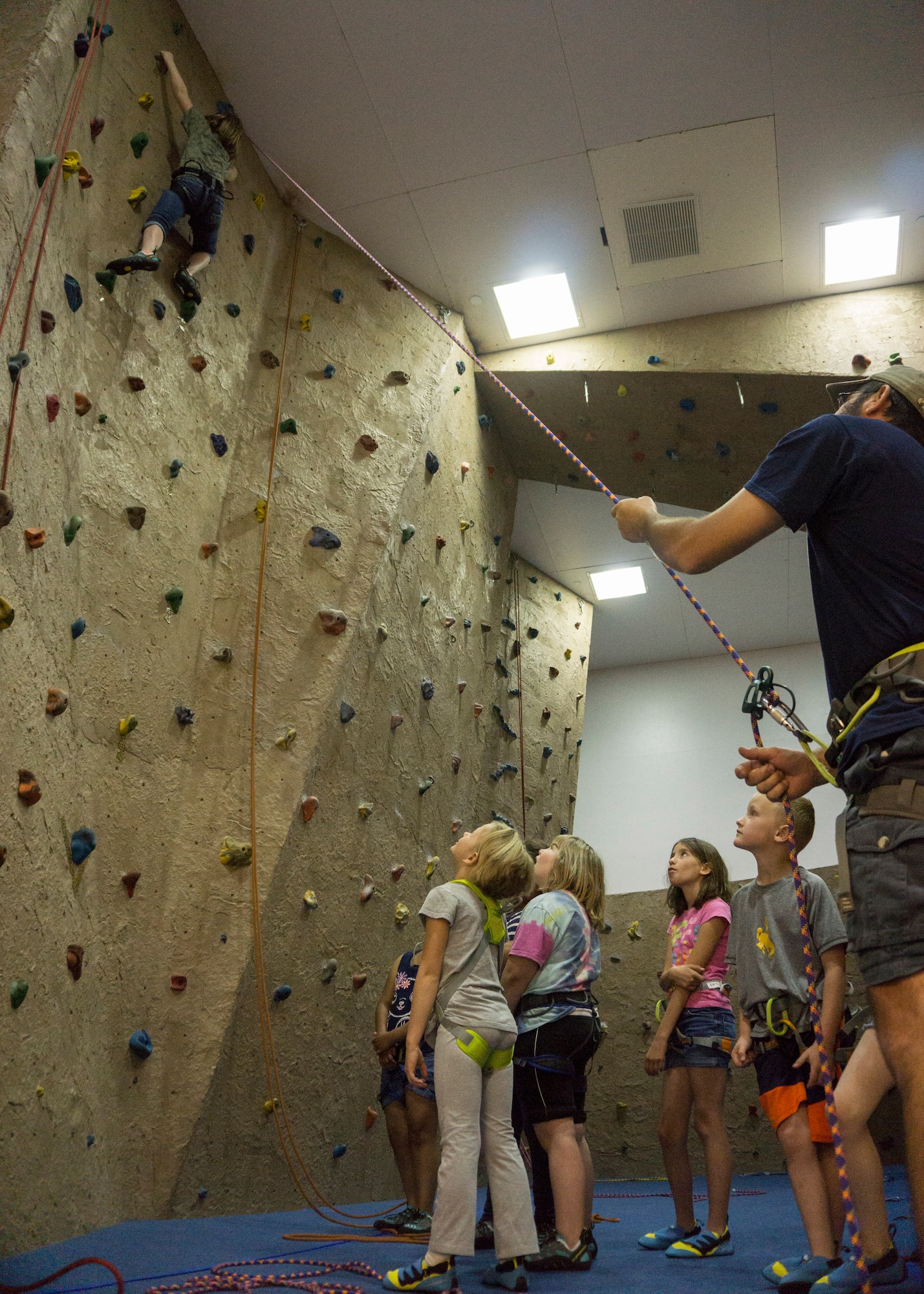 Baileigh Mitchell, 9, daughter of Master Sgt. Kenneth Mitchell, 90th Missile Security Forces Squadron, climbs the indoor rock wall in the Fall Hall Community Center on F.E. Warren Air Force Base, June 8, 2015. The rock wall was one of the activities Outdoor Recreation hosted as part of Basic Recreation Adventure Training Camp for children aged 7-10. (U.S. Air Force photo by Lan Kim)