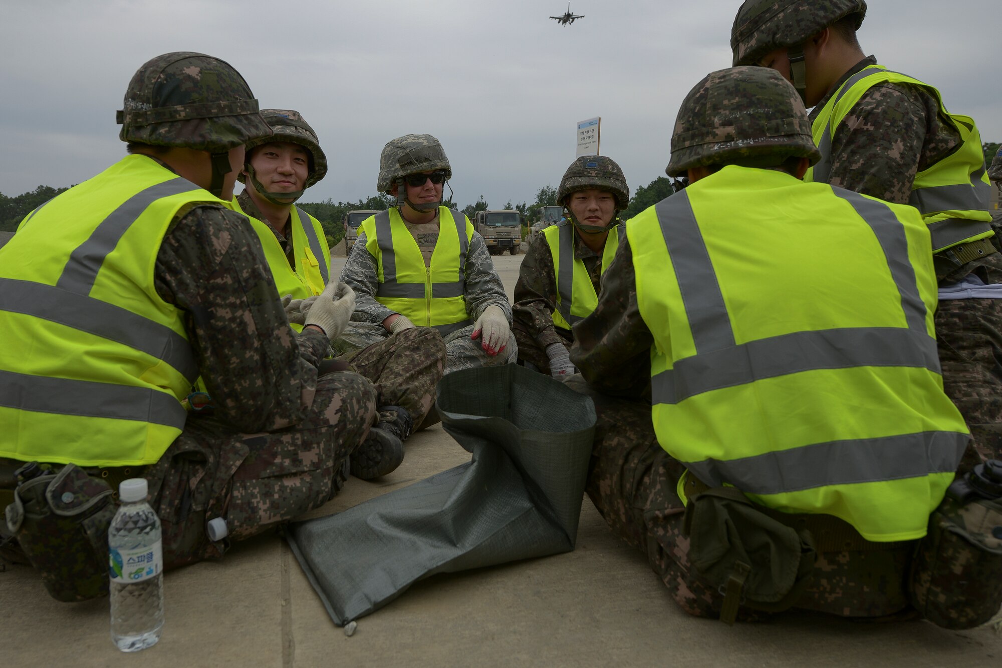 Republic of Korea and U.S. Airmen socialize during a lull in an Airway Damage Repair scenario during exercise Pacific Unity, June 11, 2015, Jungwon Air Base, Republic of Korea. These international exercises are conducted in part to expand and further develop relationships among U.S. and ROK service members, enhancing Theater Security Cooperation. (U.S. Air Force photo by Staff Sgt. Jake Barreiro/Released)