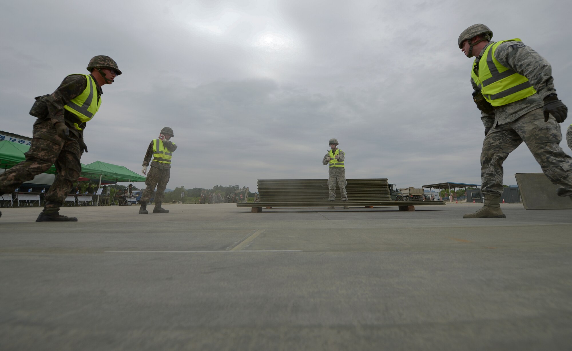 Civil engineer Airmen from the U.S. and Republic of Korea prepare a cover for a crater during exercise Pacific Unity, June 11, 2015, Jungwon Air Base, Republic of Korea. PACUNITY is a U.S. Pacific Command operation in which U.S. and ROK military forces work together to focus on providing prompt humanitarian assistance and disaster relief response capability and increase regional stability for the Asia-Pacific region. (U.S. Air Force photo by Staff Sgt. Jake Barreiro/Released)