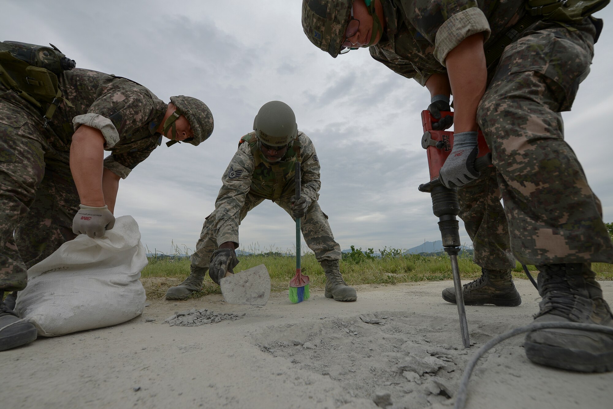 Airmen from the U.S. and Republic of Korea work together to repair a damaged runway during exercise Pacific Unity, June 11, 2015, Jungwon Air Base, Republic of Korea. The exercise was designed to give U.S. and ROK Airmen to further develop their international relationship by networking and exchanging information while working together in a simulated contingency. (U.S. Air Force photo by Staff Sgt. Jake Barreiro/Released)