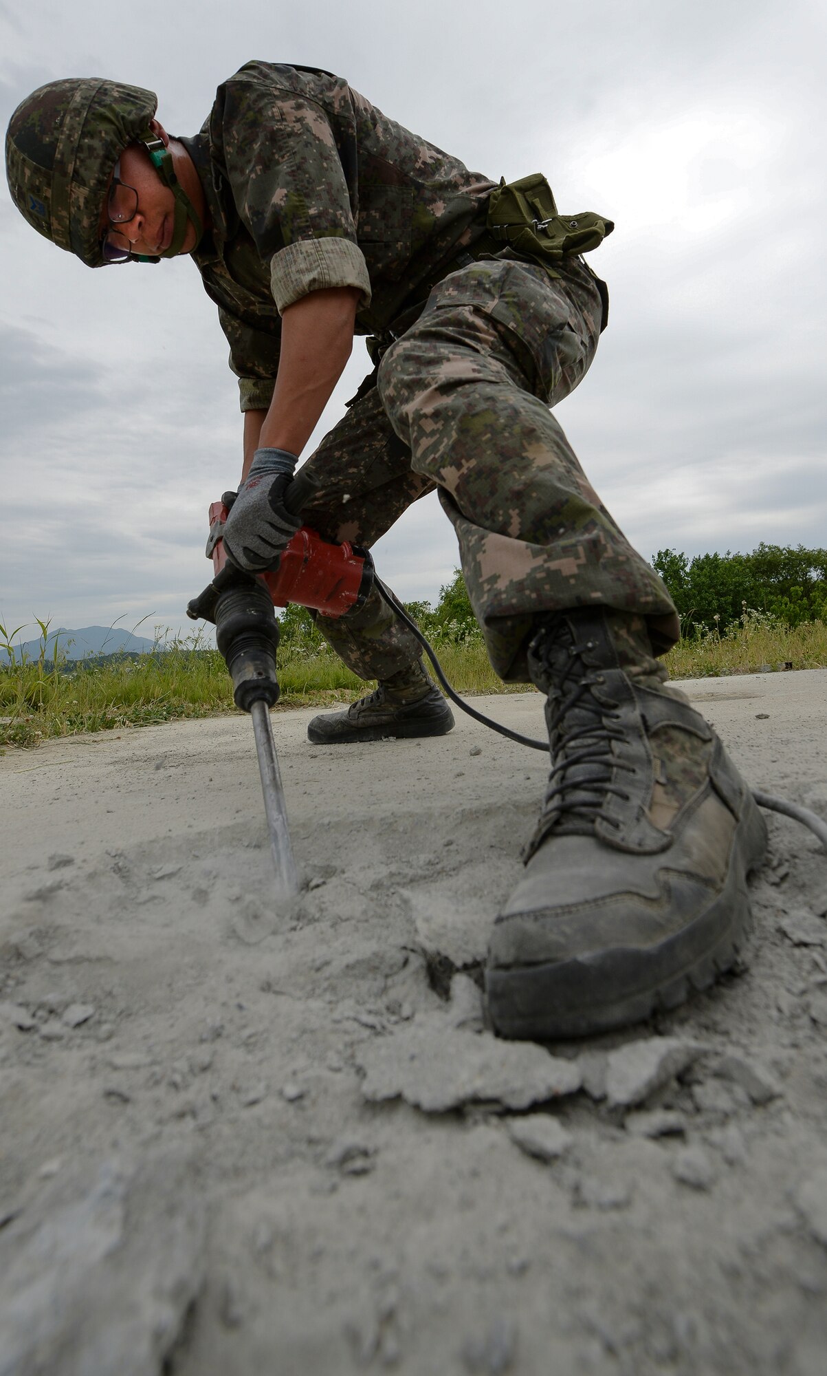 A Republic of Korea air force civil engineer drills concrete during a Airway Damage Repair scenario for Pacific Unity, June 11, 2015, Jungwon Air Base, Republic of Korea. The scenario simulated an attack that disabled a functioniong Airfield, with U.S. and ROK Airmen having to work together to repair the Airway to functionality. (U.S. Air Force photo by Staff Sgt. Jake Barreiro/Released)
