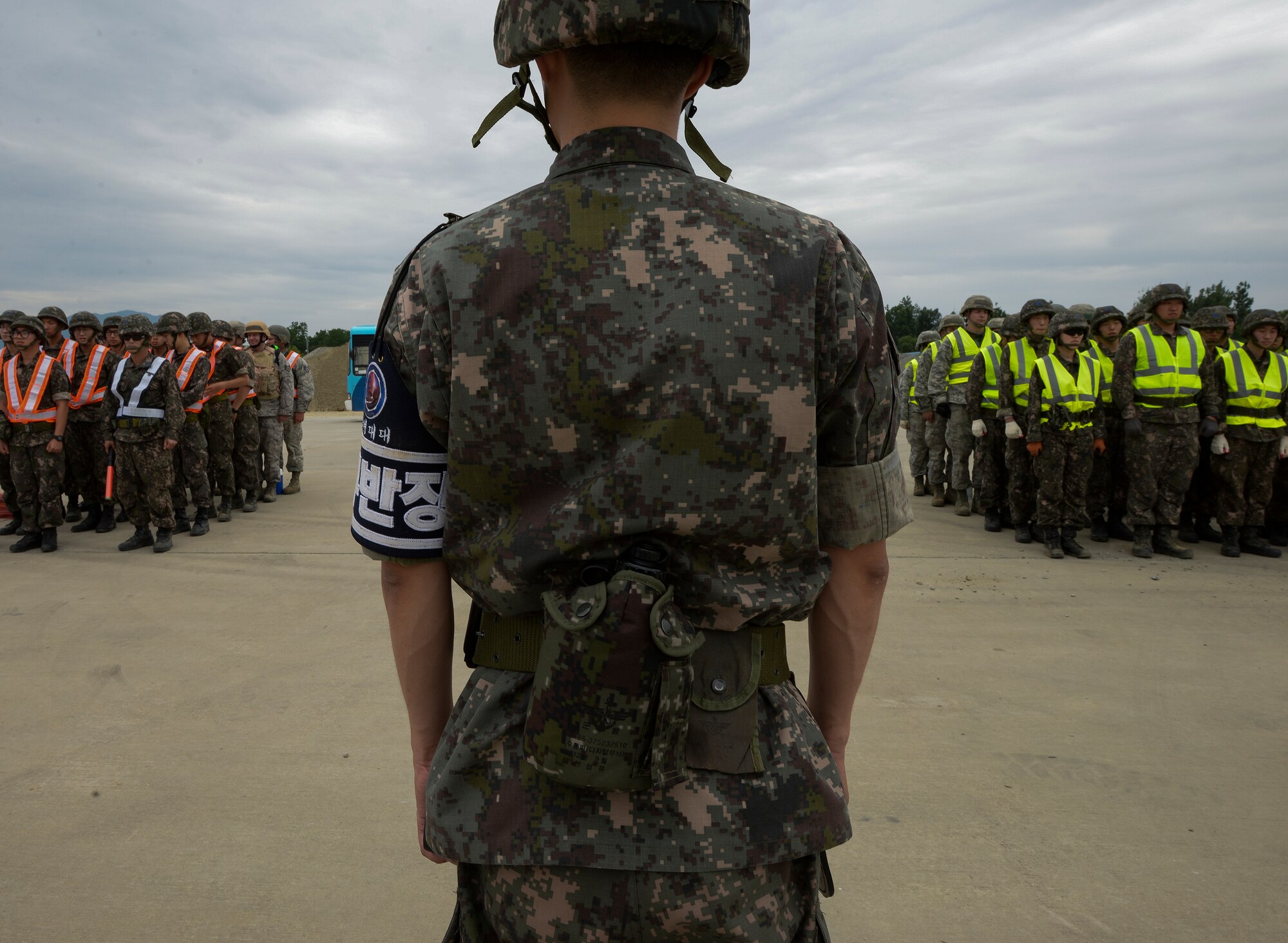 Civil engineer Airmen from U.S. and Republic of Korea assemble in formation before being dispatched to repair a runway for exercise Pacific Unity, June 11, 2015, Jungwon Air Base, Republic of Korea. PACUNITY had the goal of developing U.S. Air Force and ROK engineer interoperability for rapid responses to contingency and disaster response events. (U.S. Air Force photo by Staff Sgt. Jake Barreiro/Released)