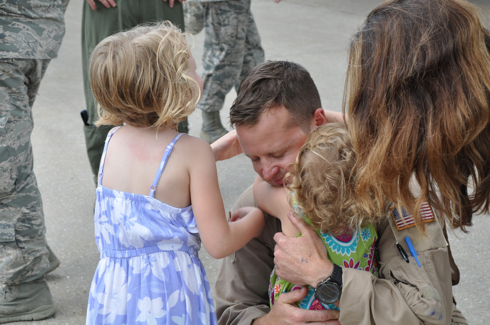 Tech. Sgt. Daniel Mills embraces his daughters (left to right) Sidney and Harper, and his wife, Master Sgt. Kyle Mills, after returning from a deployment to Southwest Asia, June 12, 2015, at McConnell Air Force Base, Kan. During the deployment, the 931 ARG performed aircraft maintenance and filled other support roles.  (U.S. Air Force photo by Tech. Sgt. Abigail Klein)