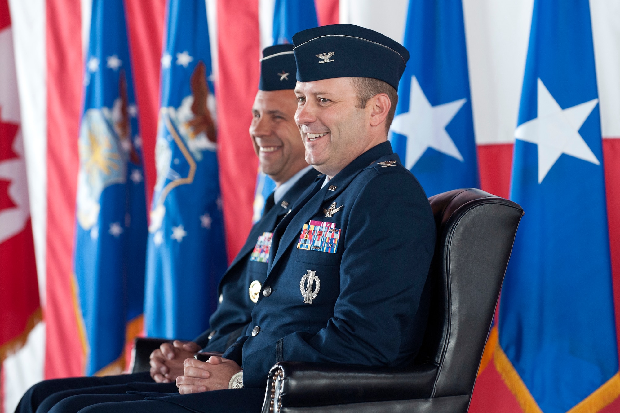 PETERSON AIR FORCE BASE, Colorado -- Col. Douglas A. Schiess (right), incoming 21st Space Wing commander, reacts to comments during the wing change of command ceremony June 12 in hangar 140. Before taking command of the wing, Schiess was Director of Space Forces, U.S. Air Forces Central Command, U.S. Central Command. (U.S. Air Force photo by Craig Denton)