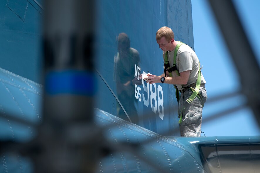 U.S. Air Force Senior Airman Christopher Still, 23d Equipment Maintenance Squadron maintenance journeyman, reapplies the tail number to a HC-130P Combat King in the President George W. Bush Airpark June 4 2015, at Moody Air Force Base, Ga. The MY accompanying the tail number of the C-130 was originally Moody’s base code before FT was introduced by the 23d Wing in 2006. (U.S. Air Force photo by Airman 1st Class Kathleen D. Bryant/Released)