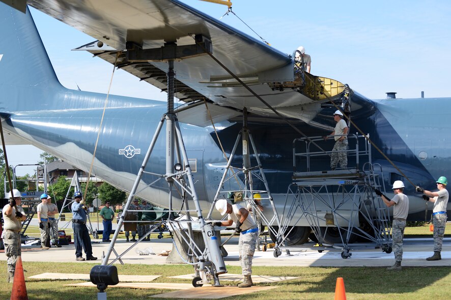 Airmen from the 71st Aircraft Maintenance Unit along with the 23d Civil Engineering Squadron attach a wing to a retired HC-130P Combat King aircraft May 19, 2015, at Moody Air Force Base, Ga. The 71st AMU and the 23d CES moved the aircraft from the flightline to reside permanently in the airpark on May 14. (U.S. Air Force photo by Airman 1st Class Kathleen D. Bryant/Released)