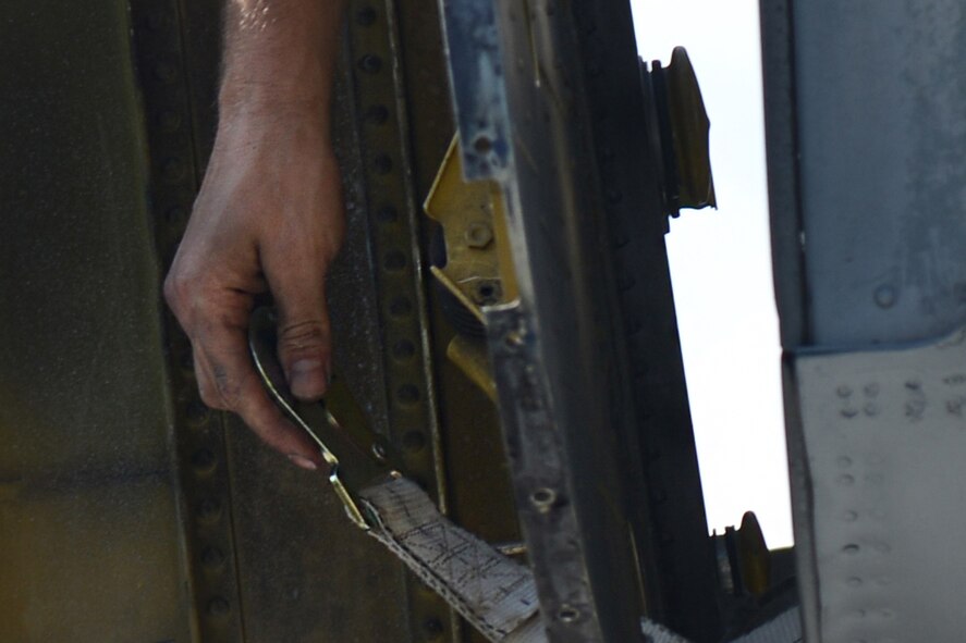 An Airman loops a strap through the wing of a retired HC-130P Combat King May 19, 2015, at Moody Air Force Base, Ga. Airmen from the 71st Aircraft Maintenance Unit and 23d Civil Engineering Squadron paired up to place the aircraft on display in the President George W. Bush Airpark. (U.S. Air Force photo by Airman 1st Class Kathleen D. Bryant/Released)