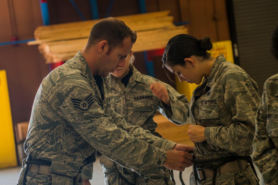 U.S. Air Force Staff Sgt. Michael Kearns, 822d Base Defense Squadron rappel tower instructor, teaches Cadet 2nd Class Angela Villarreal, U.S. Air Force Academy, Colo., how to secure a rappel jump harness June 5, 2015, at Moody Air Force Base, Ga. Villarreal and fellow cadets visited Moody to experience the operational Air Force before they commission. (U.S. Air Force photo by Airman 1st Class Dillian Bamman/Released)
