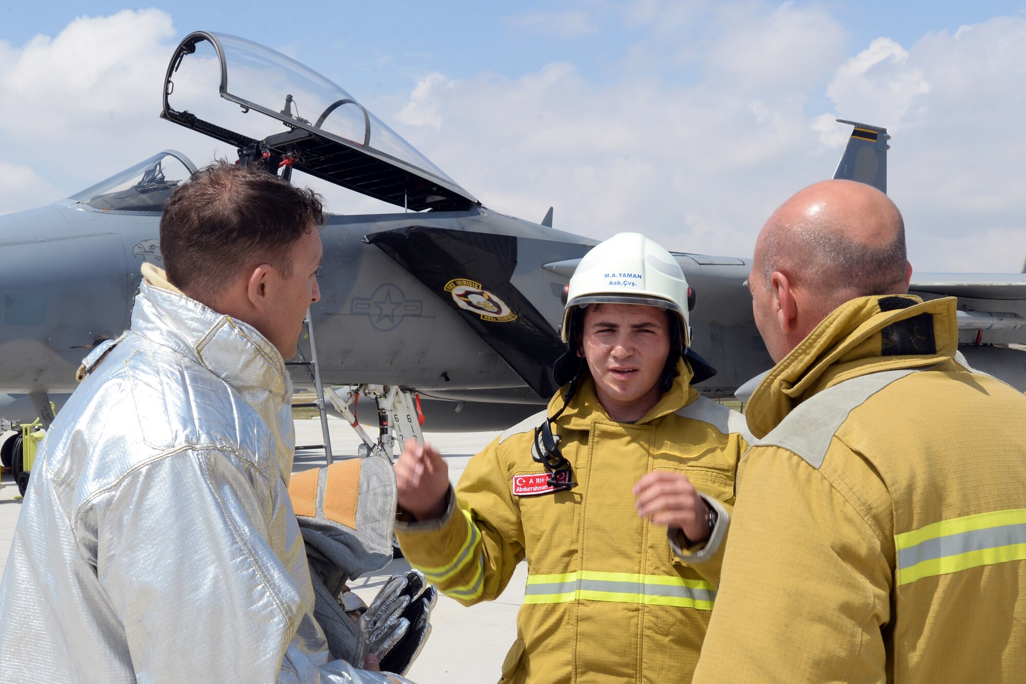 Tech. Sgt. Jeremy Hill, 48th Civil Engineer Squadron station chief, left, talks with Turkish Air Force firefighters following a proficiency exercise scenario during Anatolian Eagle 15 at 3rd Main Jet Base, Konya, Turkey, June 11, 2015. Hill facilitated a training session and the proficiency exercise to give his counterparts a basic understanding of U.S. Air Force F-15 aircraft recovery procedures following a reported in-flight emergency. (U.S. Air Force photo by Tech. Sgt. Eric Burks/Released)
